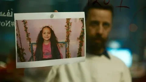 A mand holds up a photo of Hind Rajab