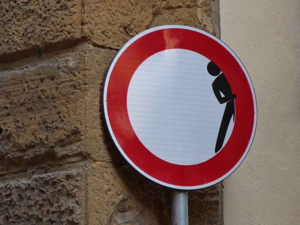 Road sign with a twist - person hiding within the warning sign
