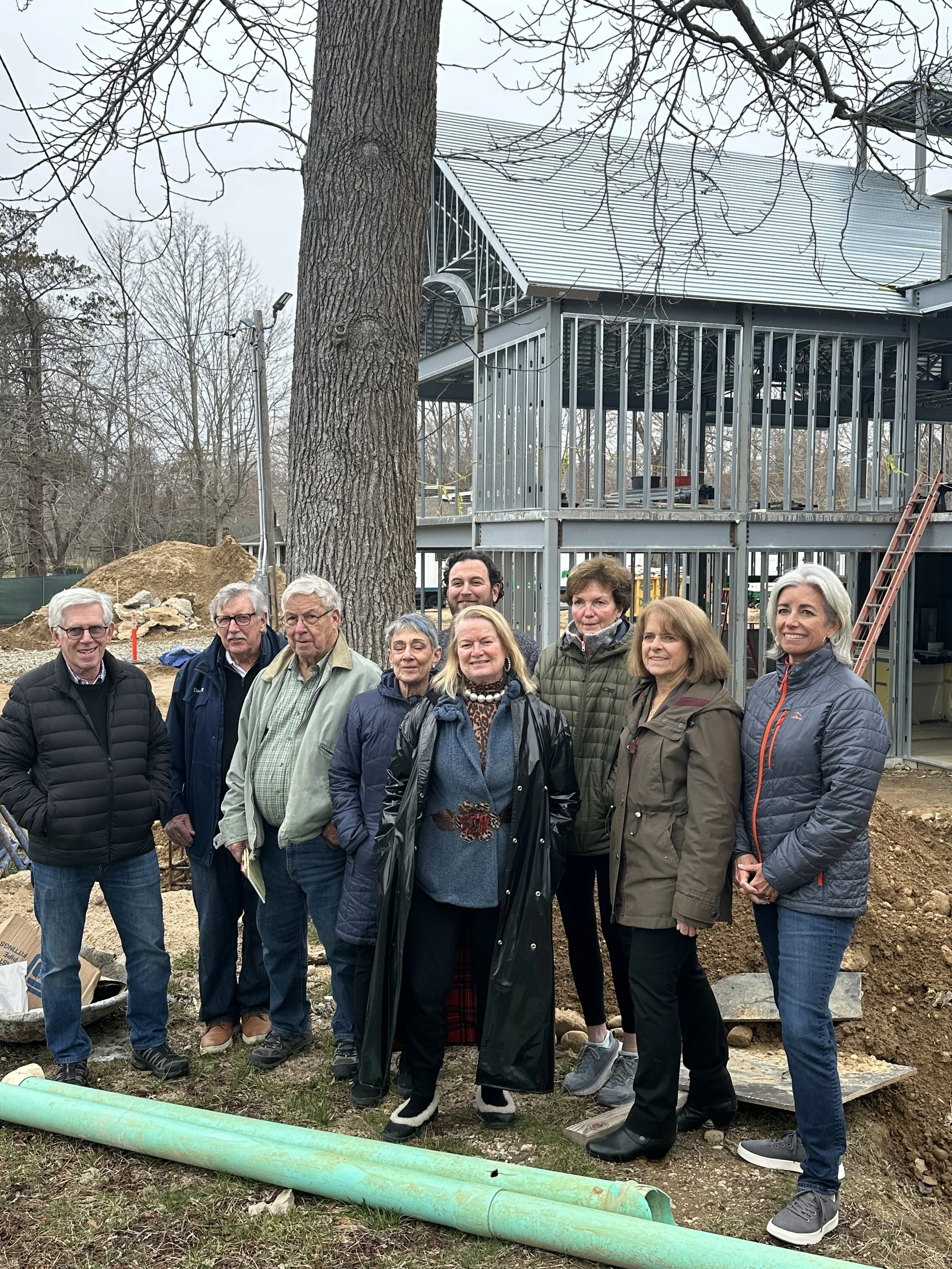 Shelter Island Board of Trustees standing in front of metal skeleton on new library addition.