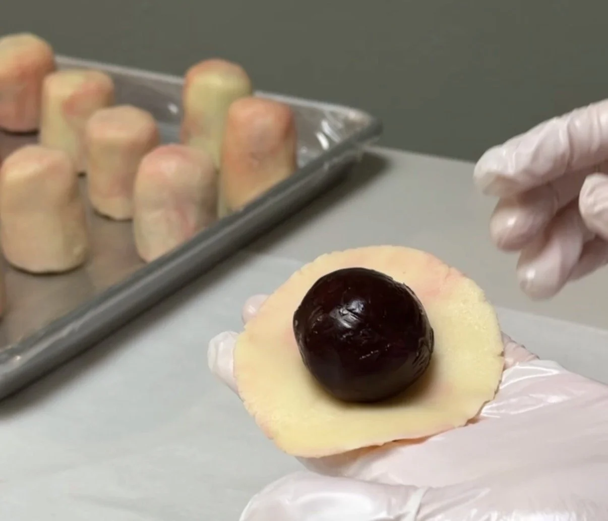 hands-wrapping-peach-dough-around-filling-ball.jpg