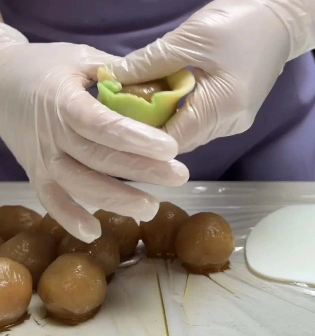 hands-wrapping-green-marbled-dough-around-filling.jpg