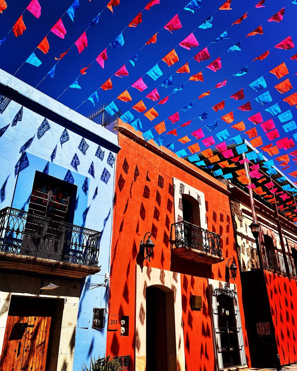 bright colored two story buildings with colorful flags hanging above