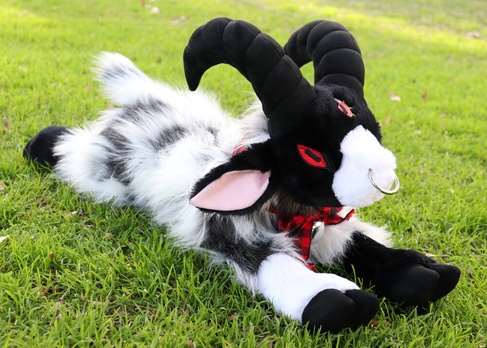 Plush toy of a lying down goat