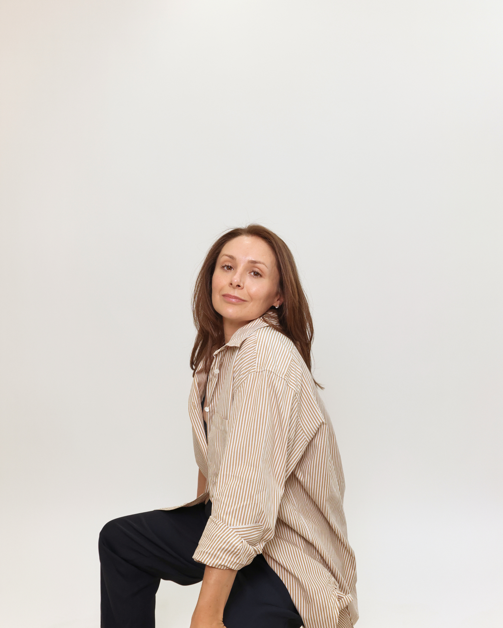 Profile image of Charlie Perry Skin Facialist sitting down with black trousers and striped shirt