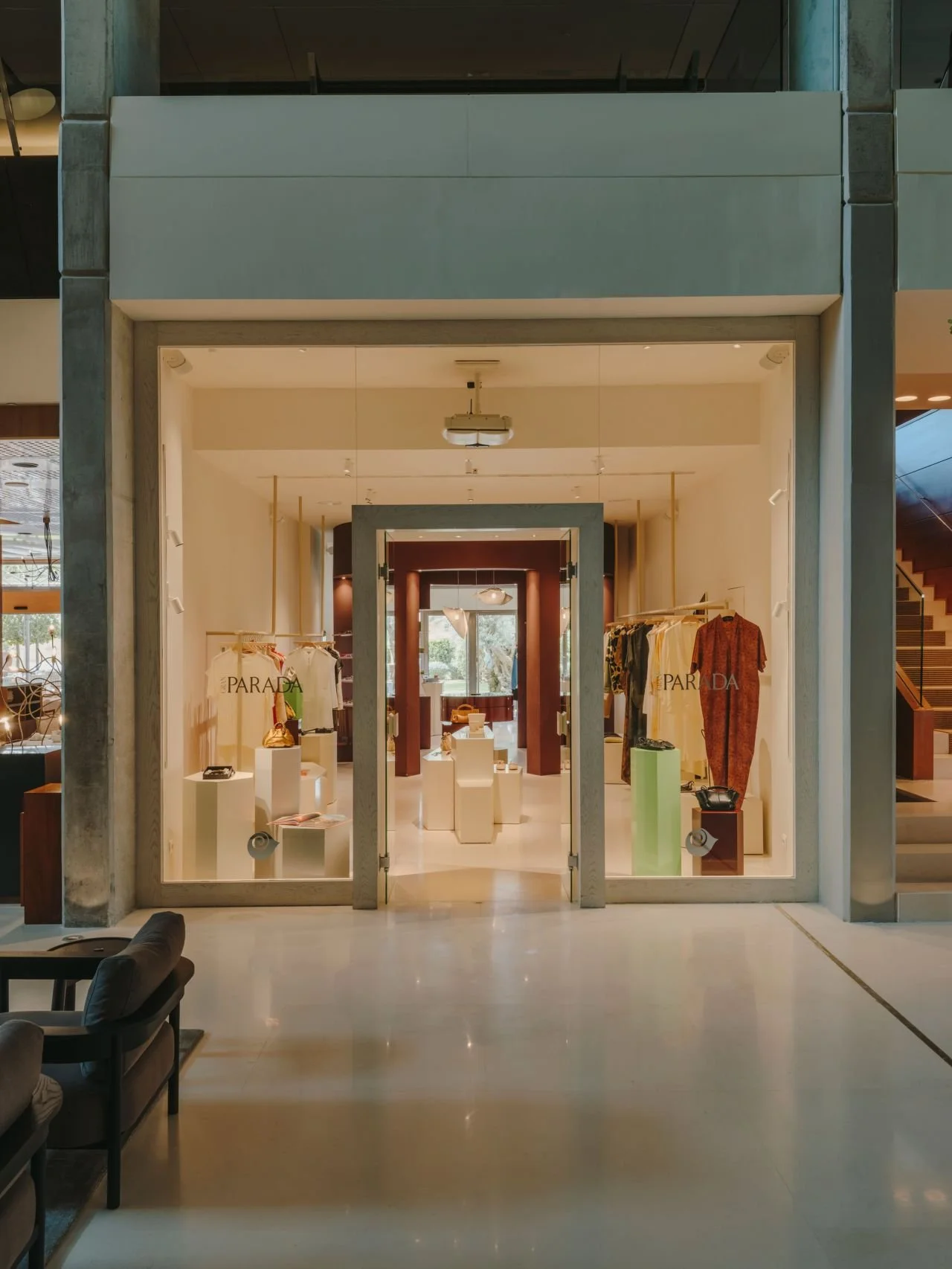 Vitrina de tienda con ropa y accesorios, con señal de 'Parada' en las paredes, en un centro comercial.