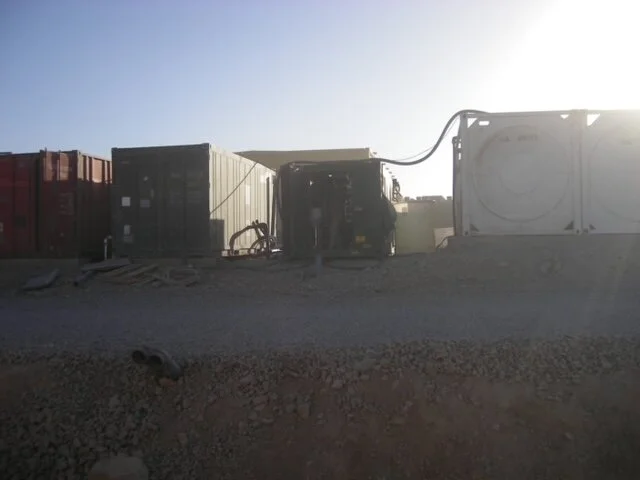 Vincent: ‘Dit was de opstelling zoals we op Deh Rawood stonden. Rechts zie je witte containers, dat waren er drie in totaal stuks. Daarin kwam het grondwater terecht, wat via twee pompen omhoog werd gepompt. Via de slang op de foto werd gemiddeld 13m3 water per uur door ons systeem geleid. Dit leverde ongeveer 3,5 kubieke meter schoon drinkwater per uur op. Hierbij moet wel de kanttekening worden geplaatst dat dit water ‘schoon’ was van alle mineralen en andere stoffen uit de bodem, maar er zat wel chloor in ten behoeve van de houdbaarheid van het water.’