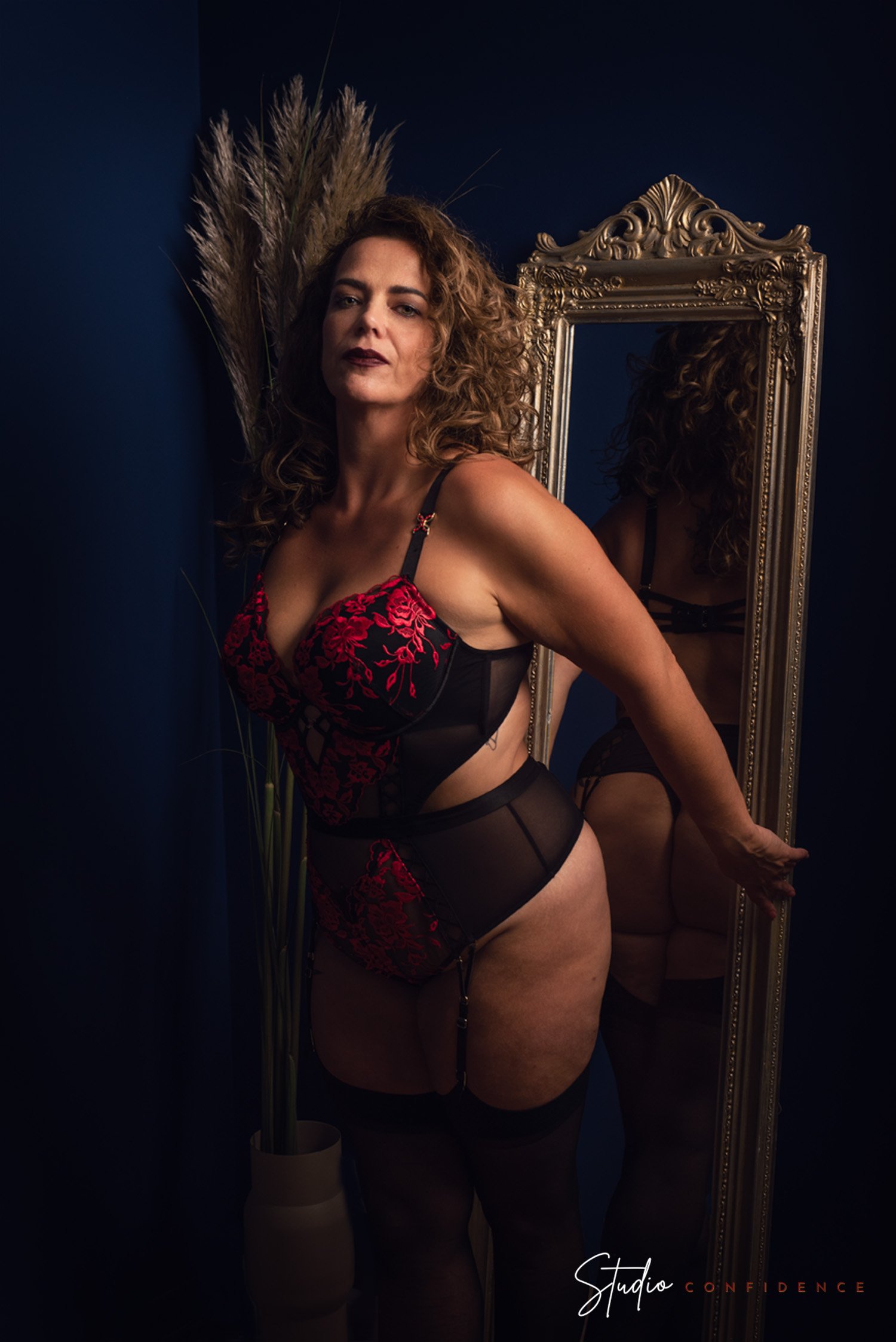vrouw voor spiegel in lingerie met krullen en make-up
