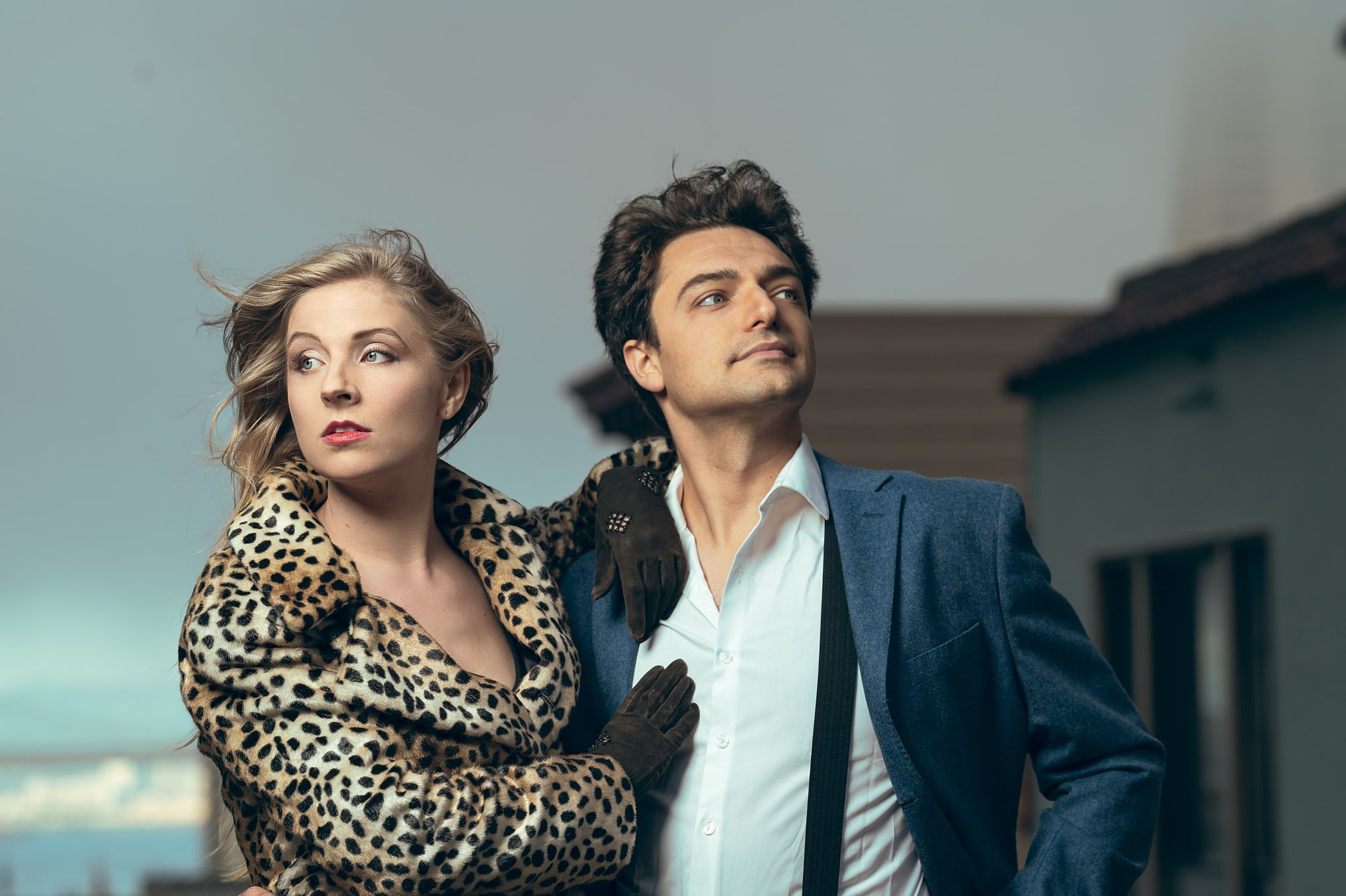 Stijlvolle koppelshoot in Gent met een vrouw in luipaardjas en man in blauw kostuum — creatieve portretfotografie met editorial flair door een fotograaf uit Oost-Vlaanderen.