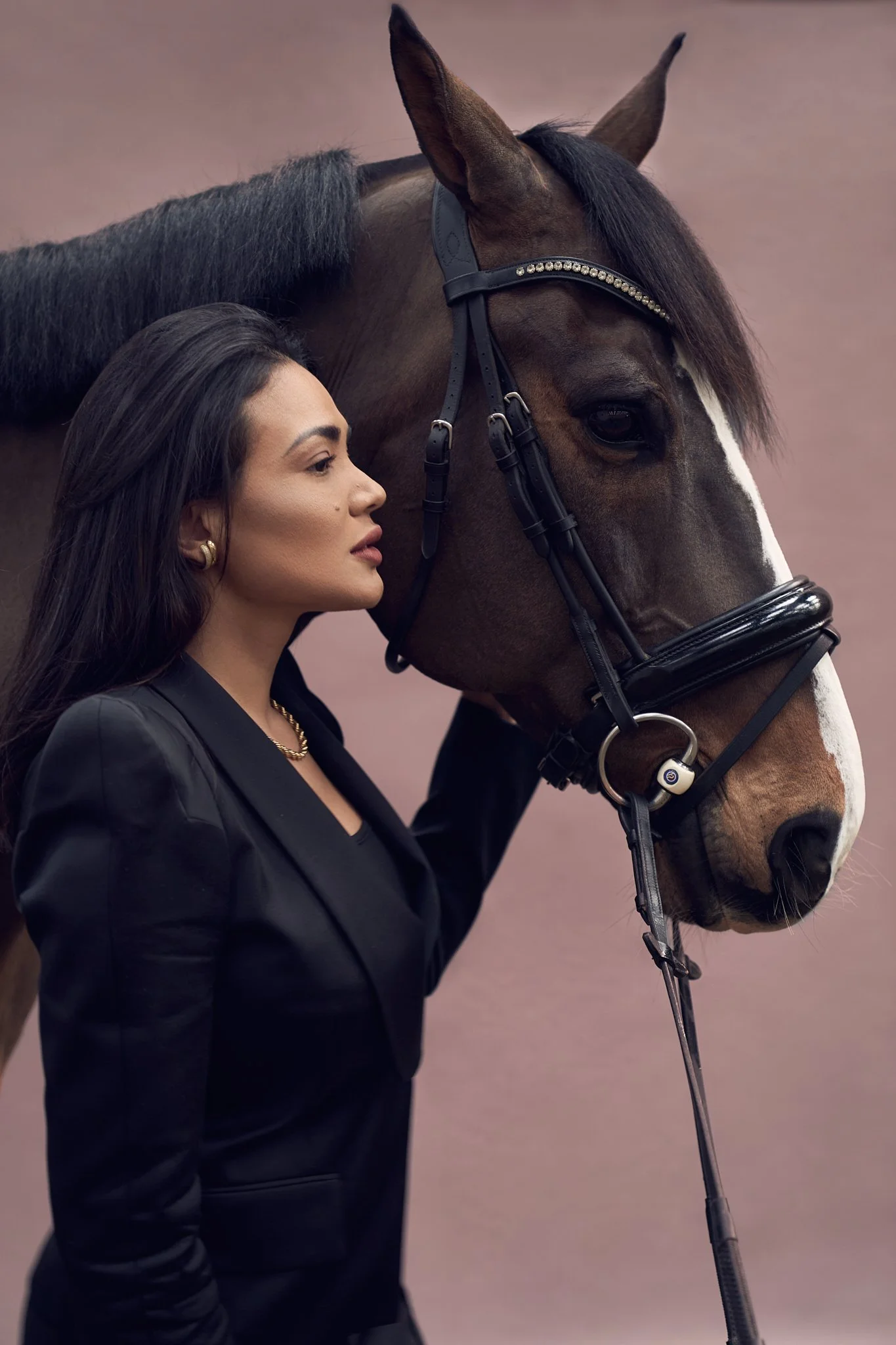 Elegant fine art portrait of a woman standing beside a horse, photographed in Belgium in a luxury portraiture style.