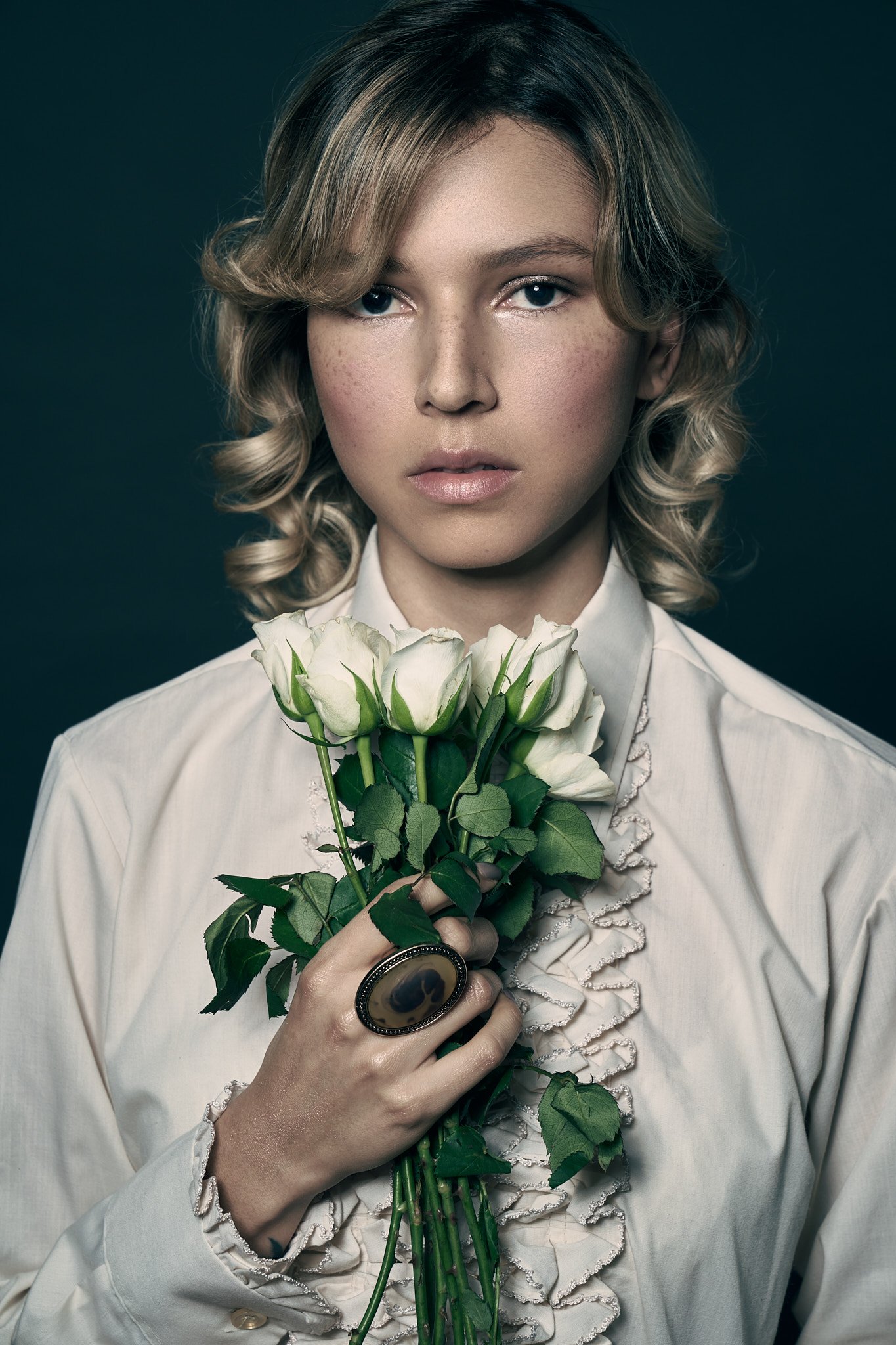 Portrait éditorial d’une mannequin tenant des roses blanches — séance portfolio artistique réalisée par un photographe mode à Gand.