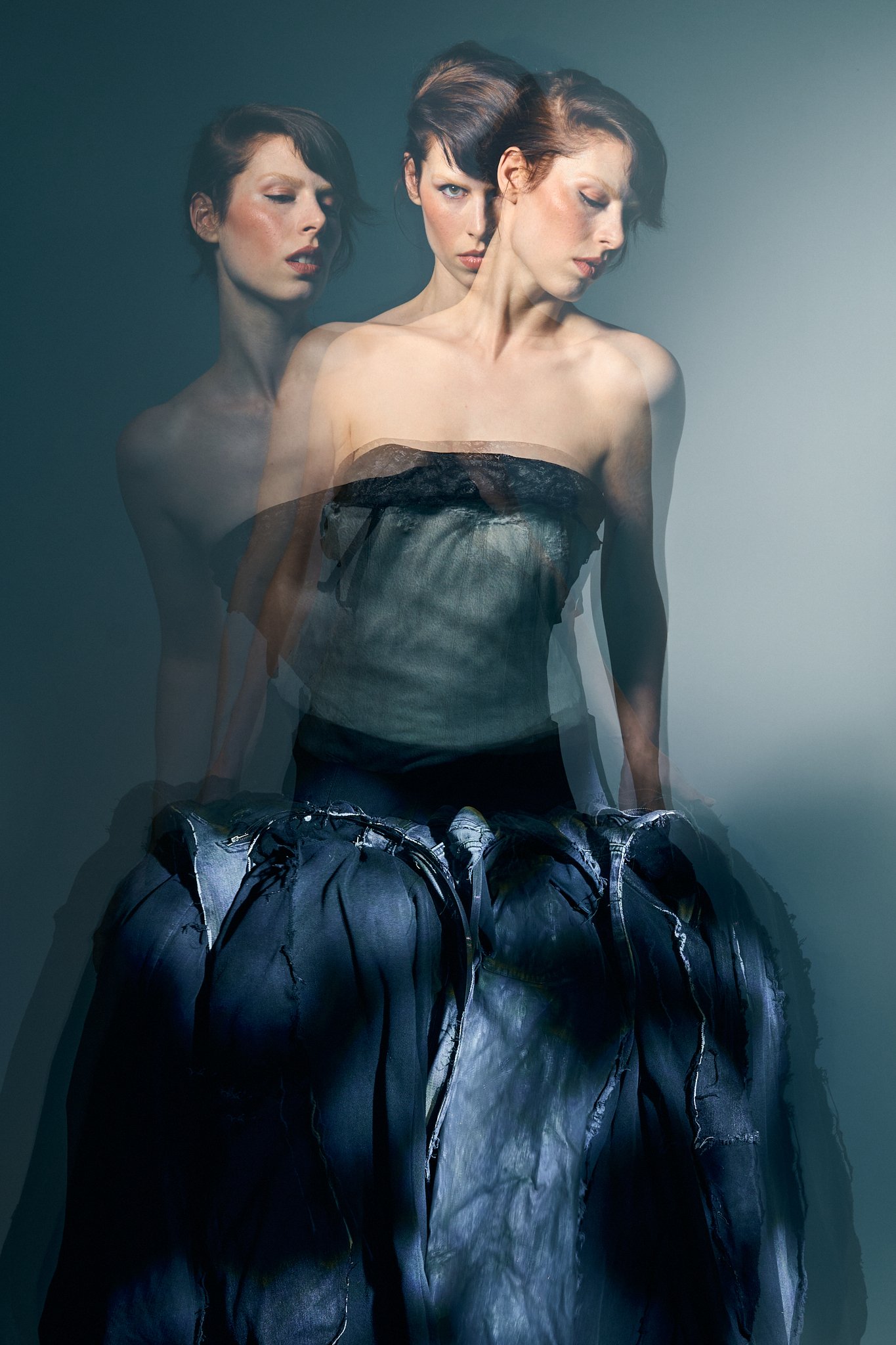 Avant-garde fashion editorial featuring a model in a sculptural black gown with artistic multiple exposure effects, creating a surreal fine art portrait by a Belgian fashion photographer.
