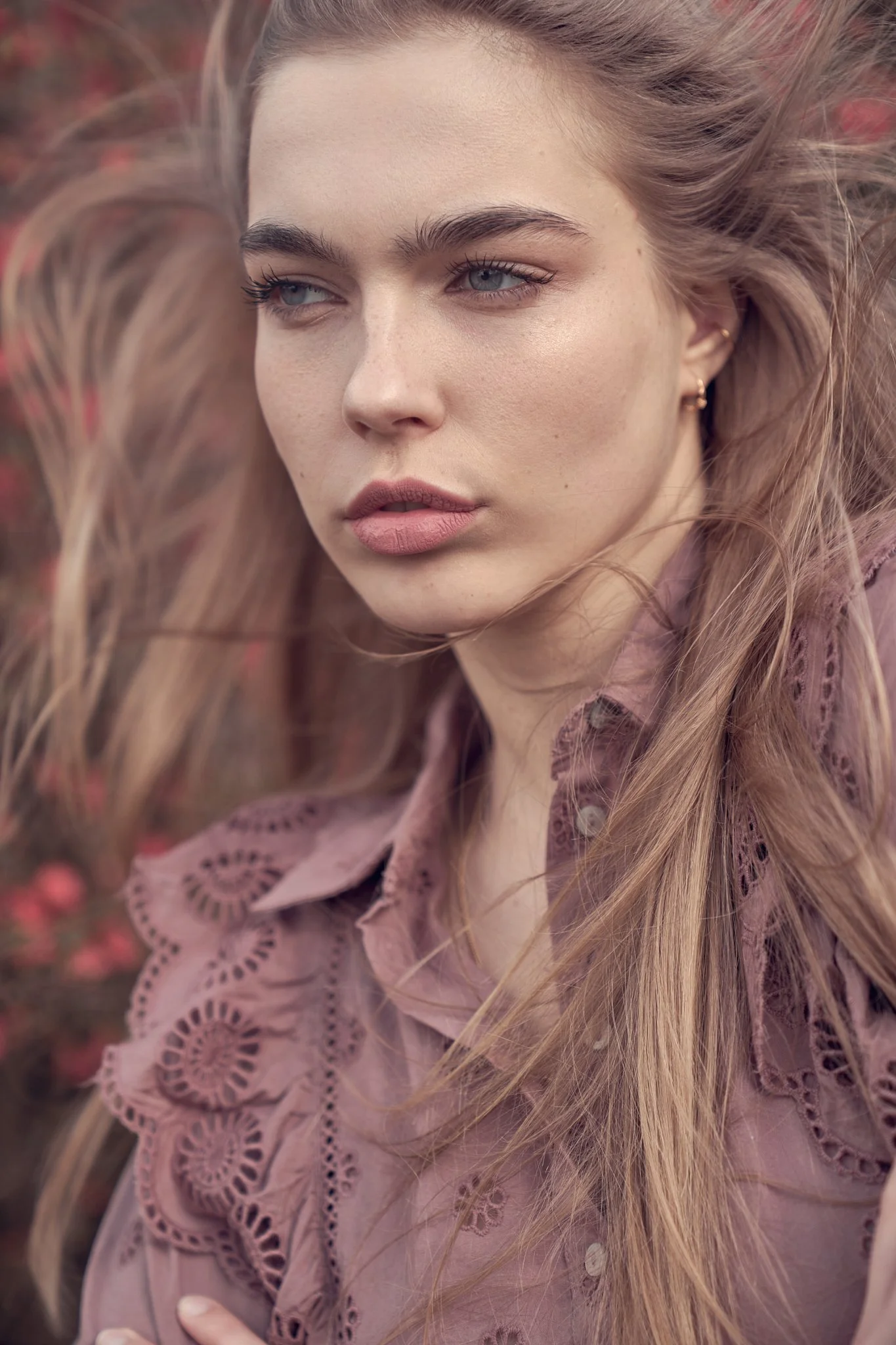 Fine art close-up portrait of a woman with flowing hair and warm tones, photographed in Belgium in a luxury editorial style.