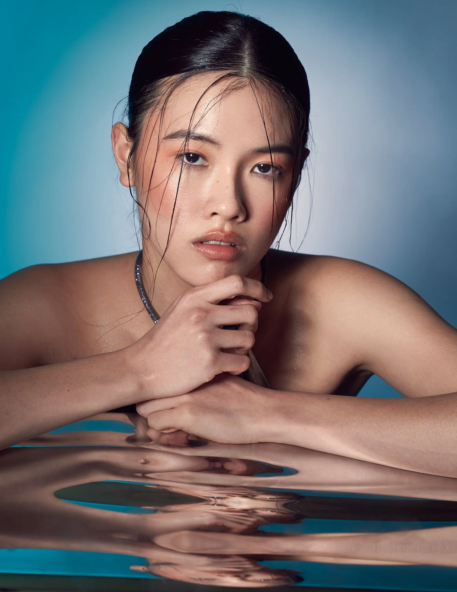 close-up beauty portrait of Asian model with wet-look hair and water reflection