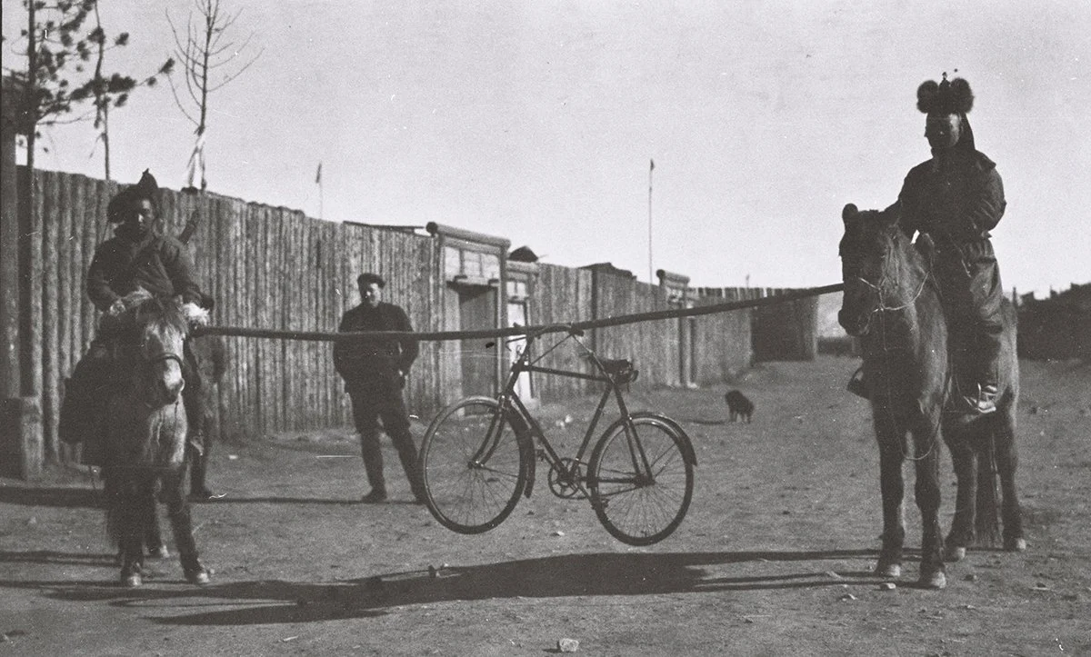  Lobsen Yantsang &amp; servant mounted &amp; carrying a bike between them on pole, O.M. behind/TAR 