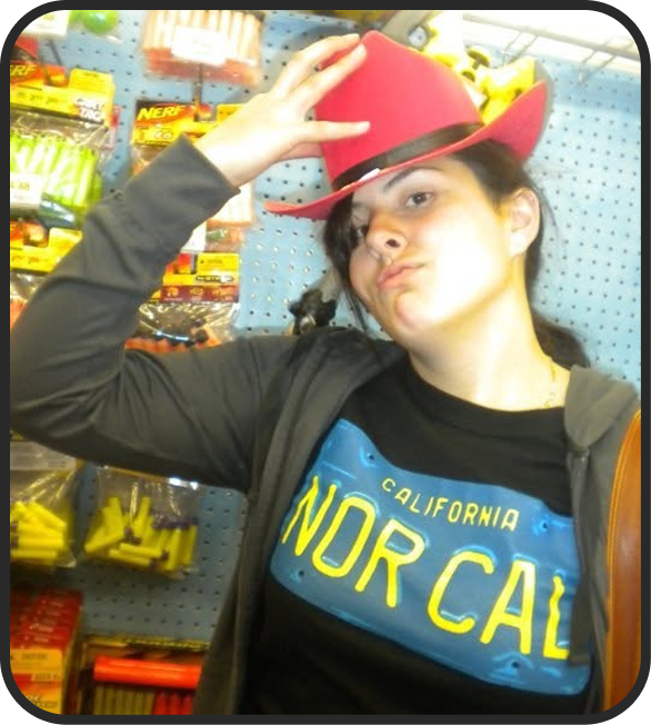Young woman wearing a red cowboy hat and a black T-shirt with California NOR CAL text, posing inside a store aisle with various colored products on the shelves behind her.