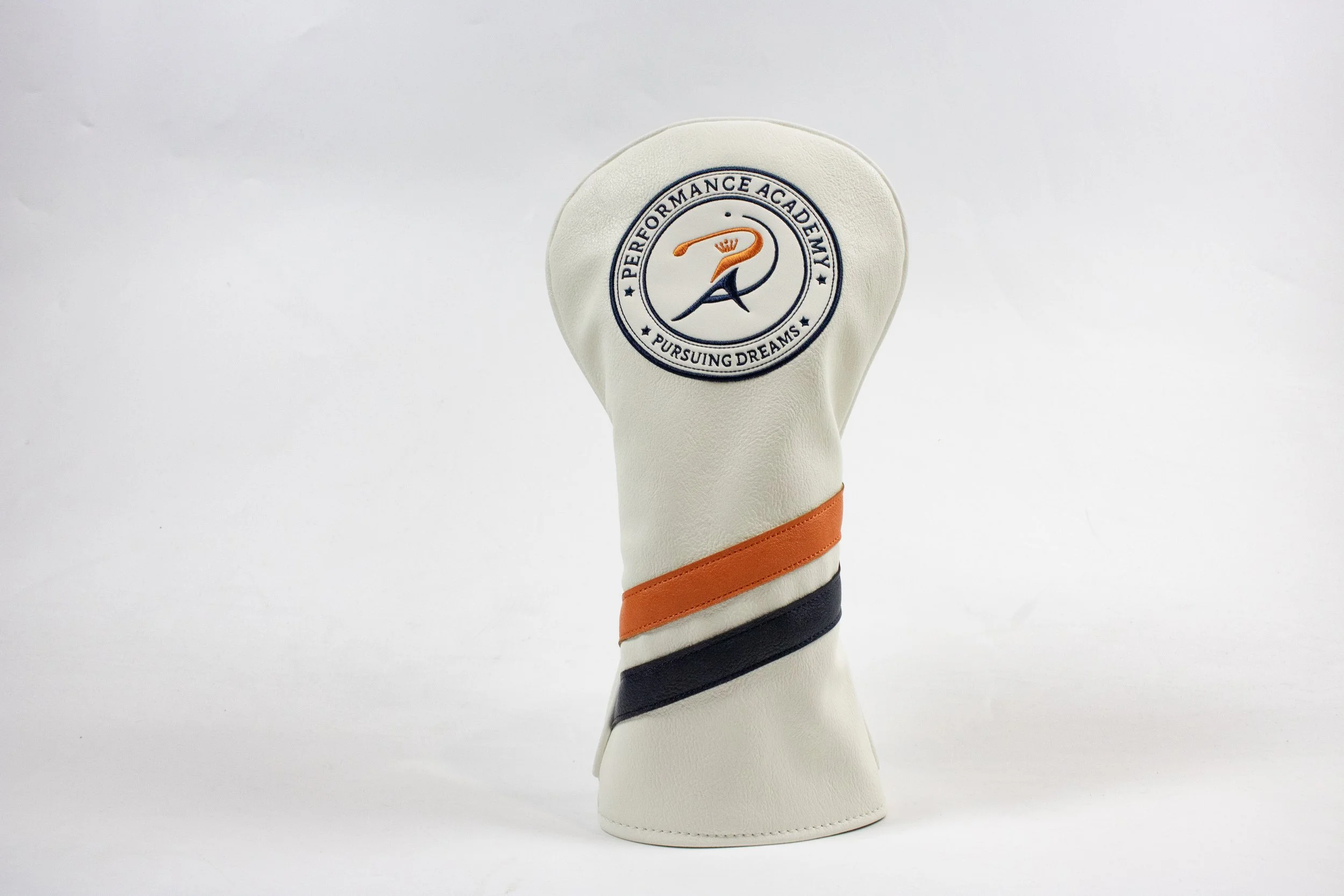 Golf club headcover with embroidery of a flamingo, surrounded by the text 'Performance Academy' and 'Pursuing Dreams' on a plain white background.