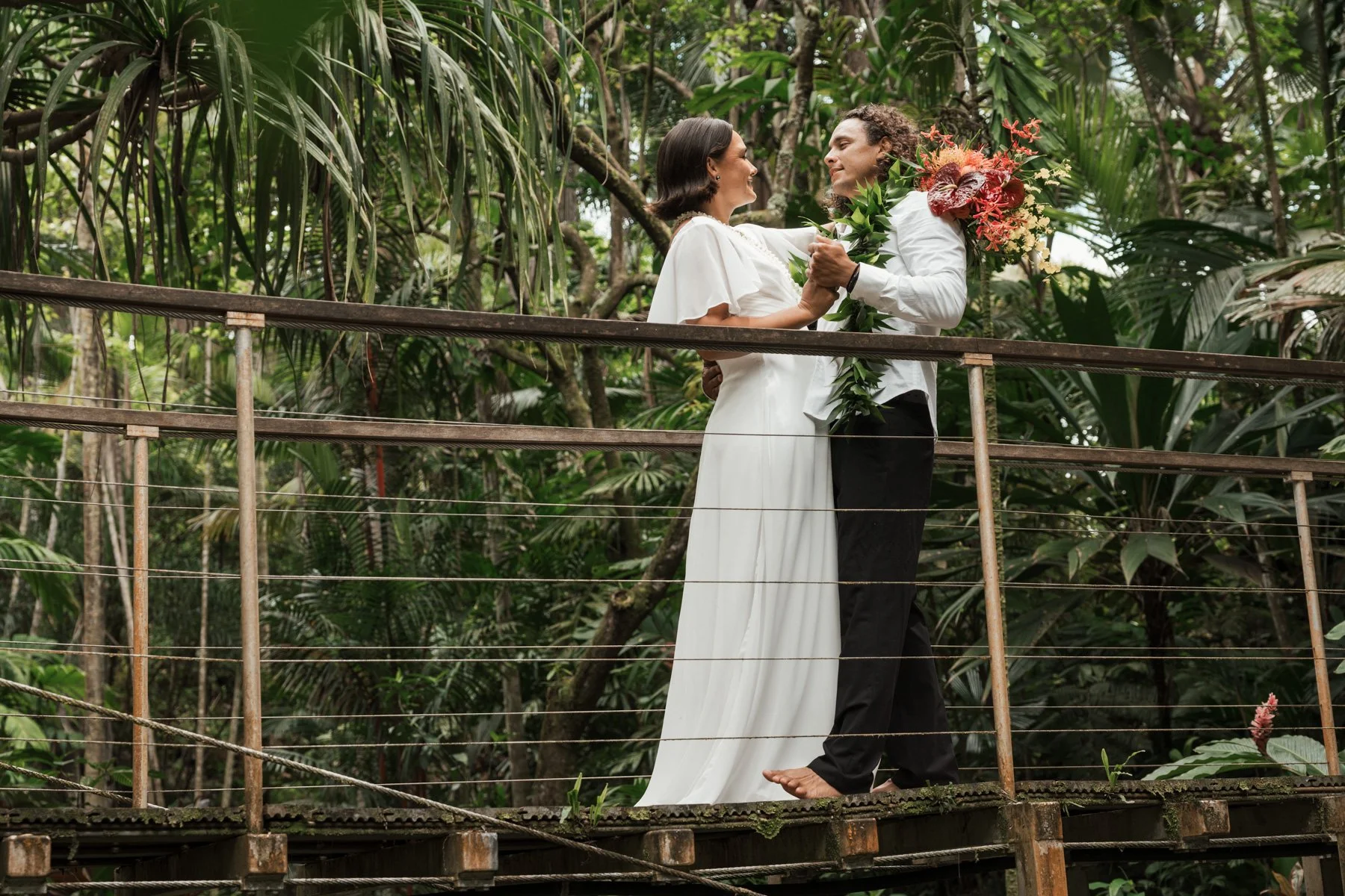 bride and groom dancing on bridge at Princeville Botanical Garden on Kauai