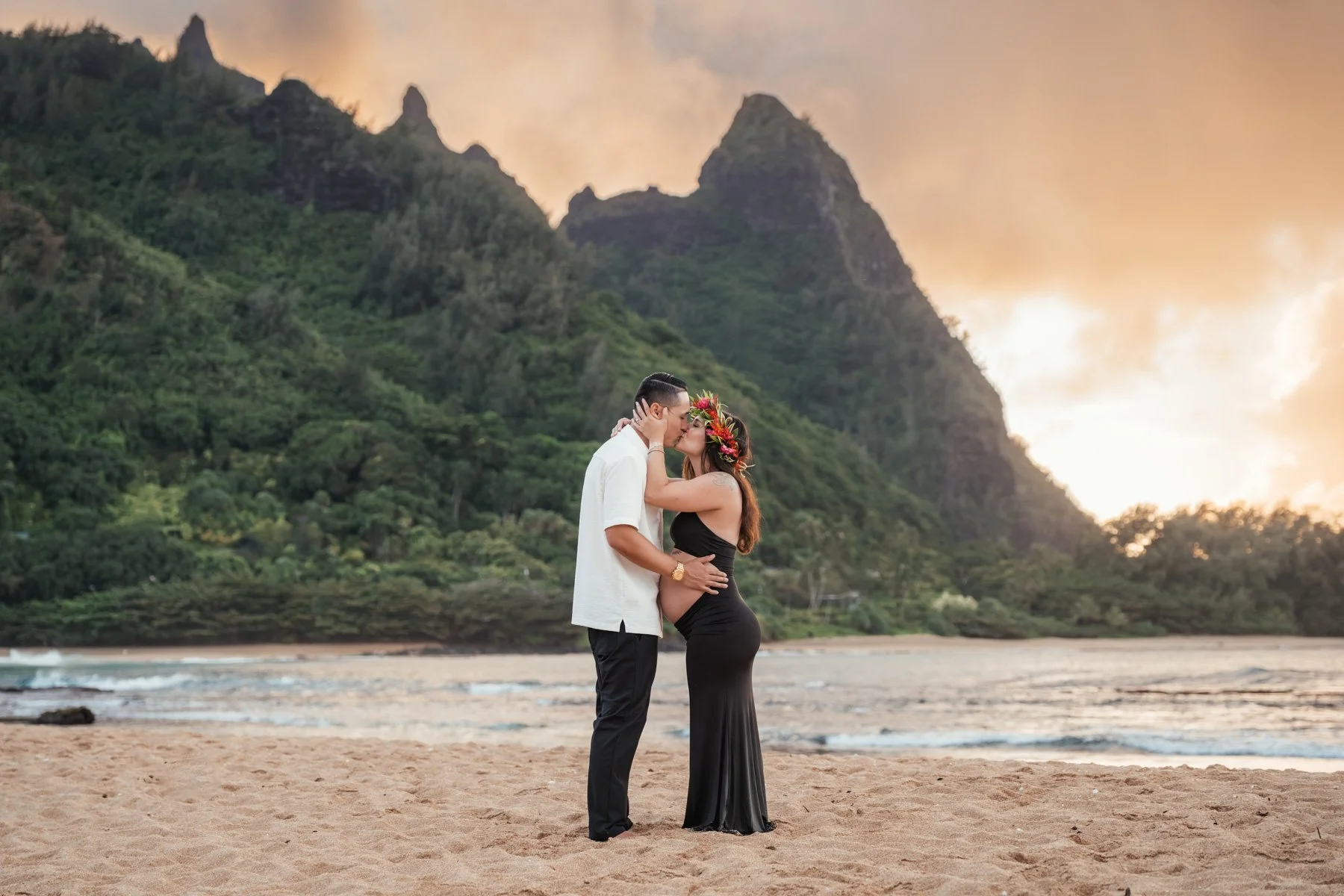 Maternity photography of expecting mother and father along water along the shores of Kauai