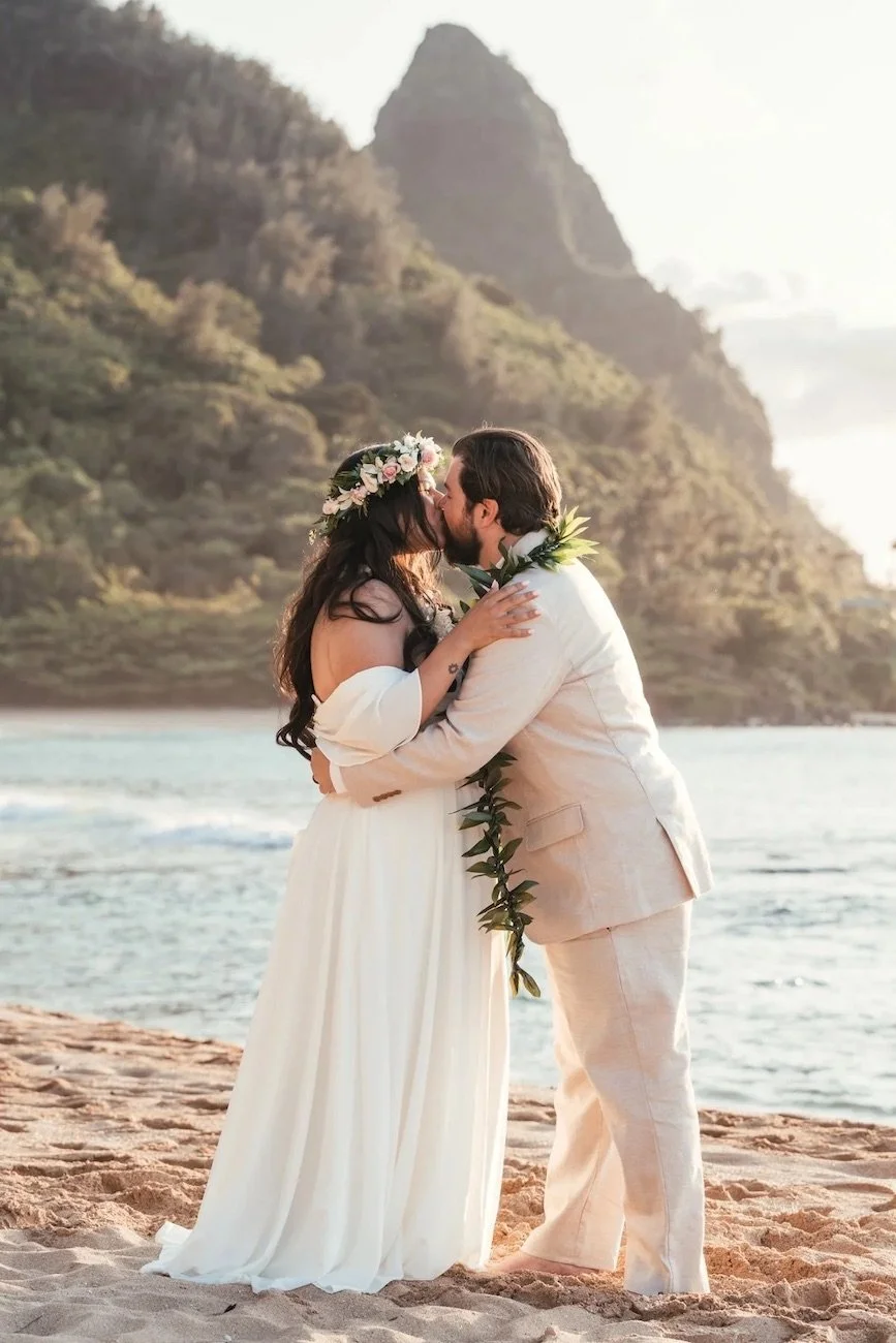 couple kissing during sunset wedding at tunnels beach