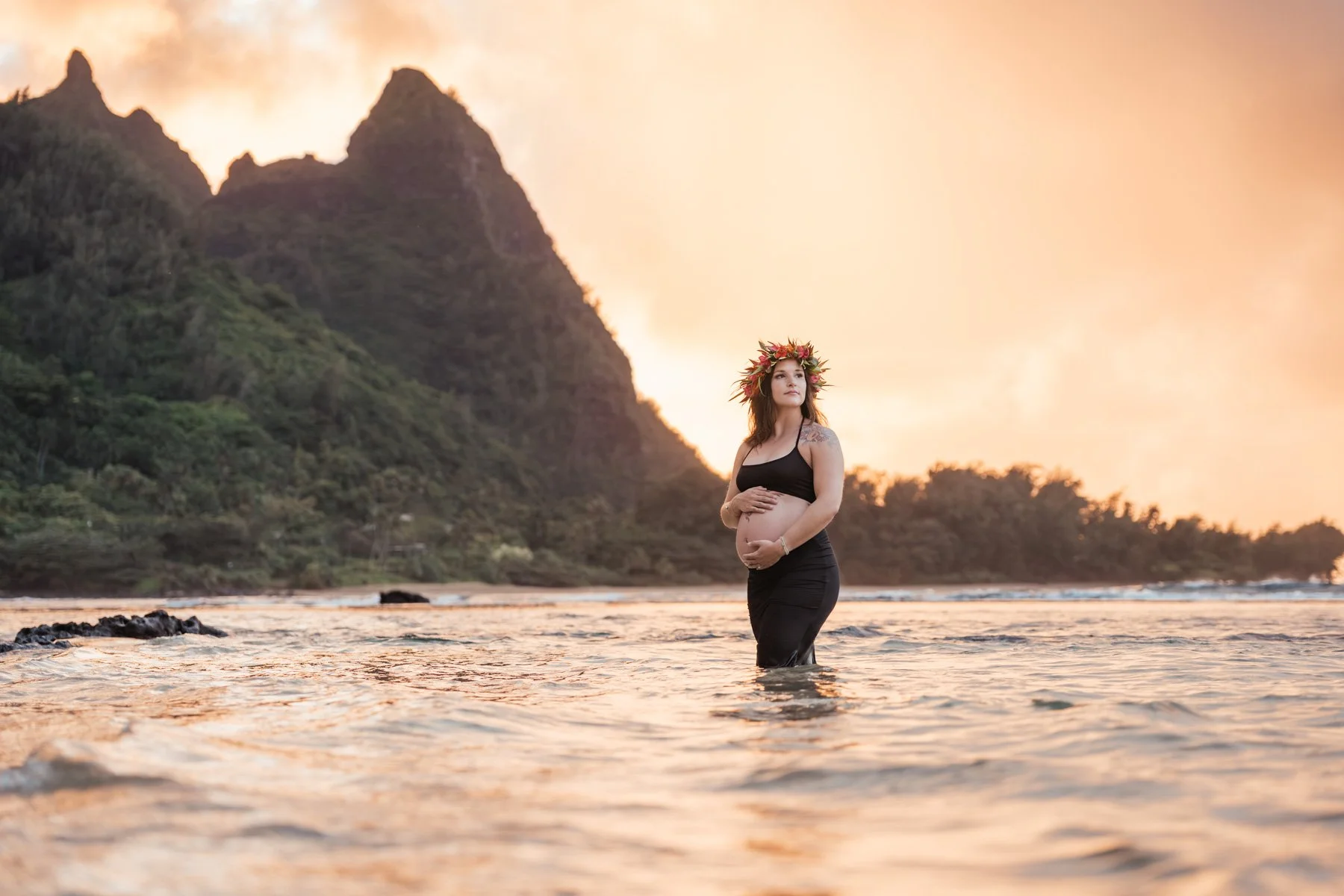 Maternity photography of expecting mother in water along the shores of Kauai