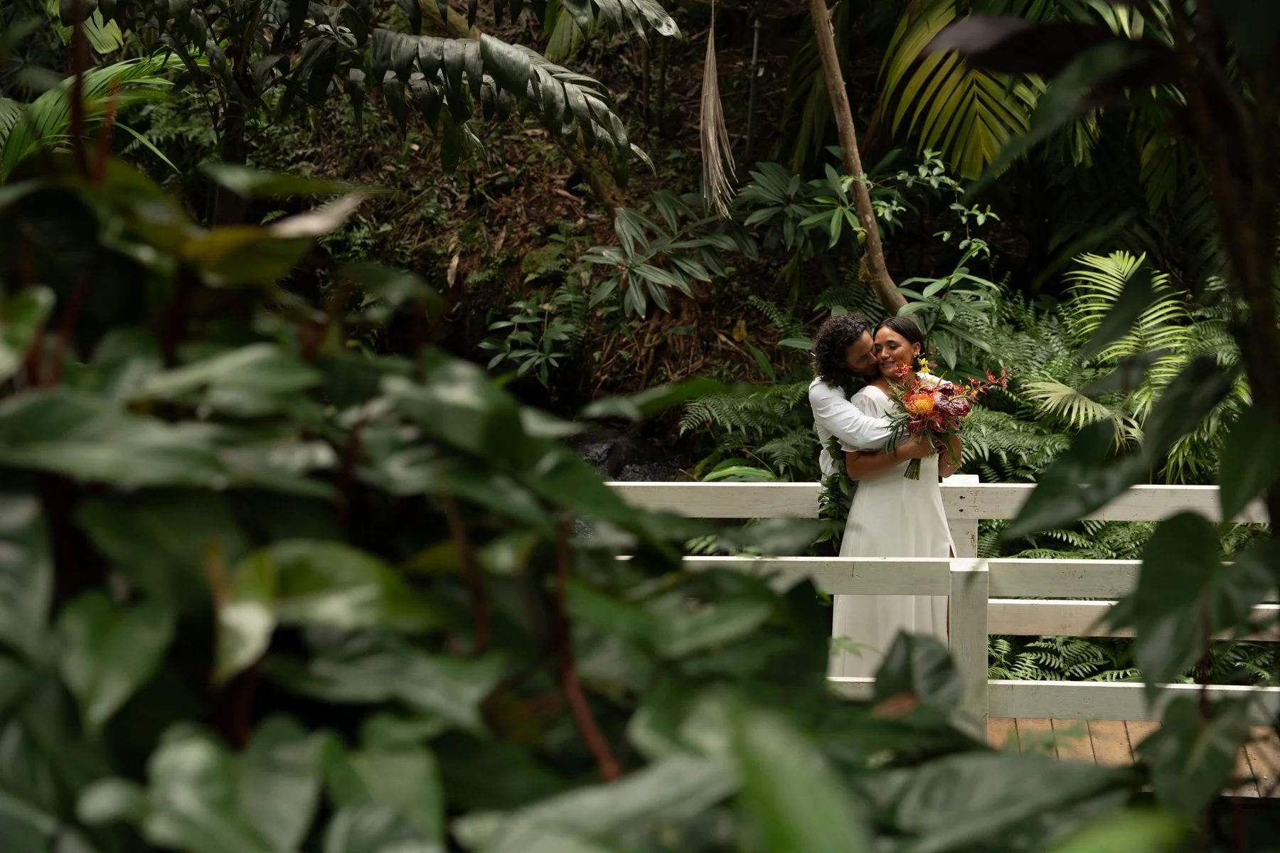 Bride and groom embracing after wedding ceremony at Princeville Botanical Garden