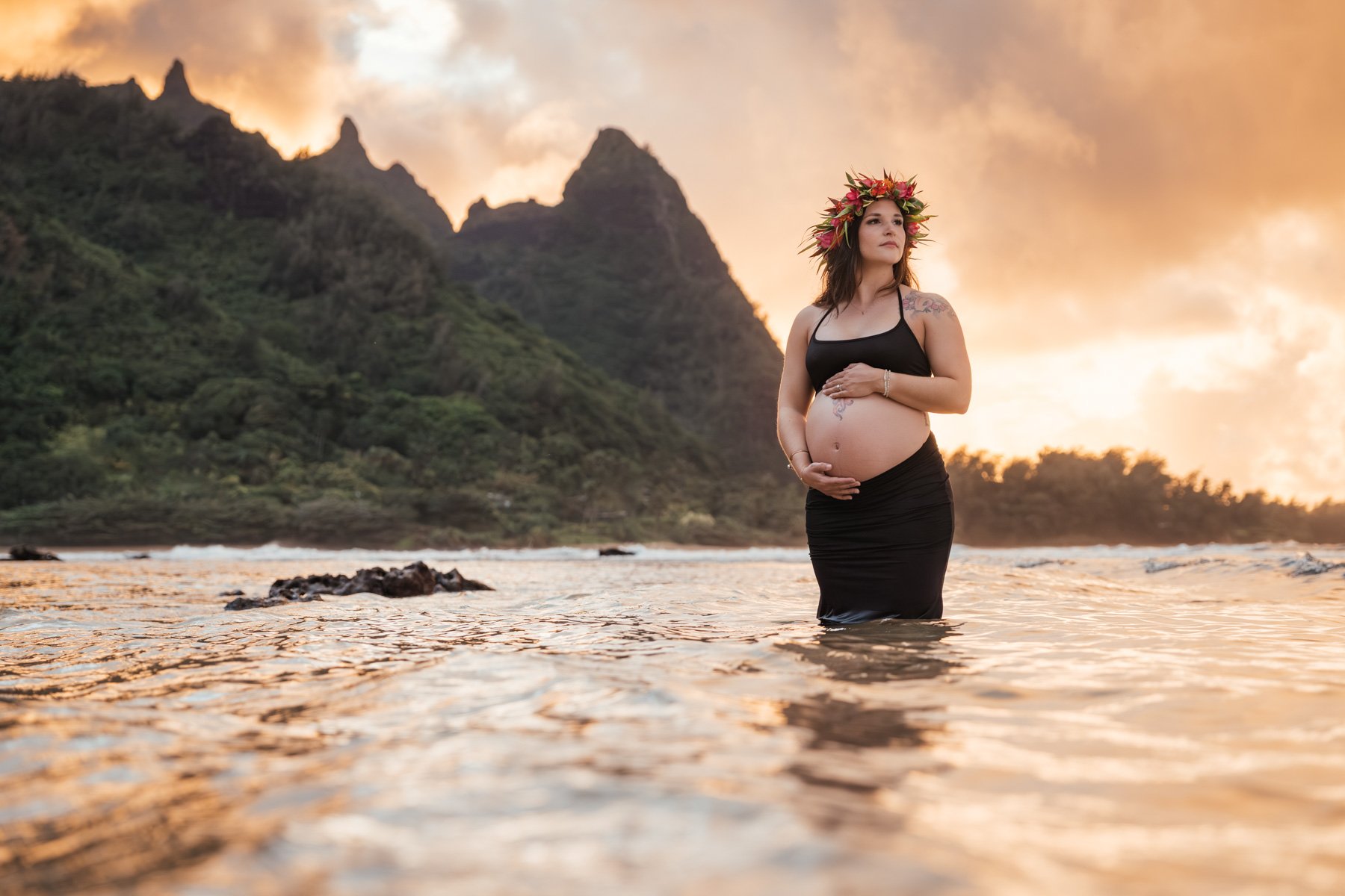 Maternity photography of expecting mother in water along the shores of Kauai