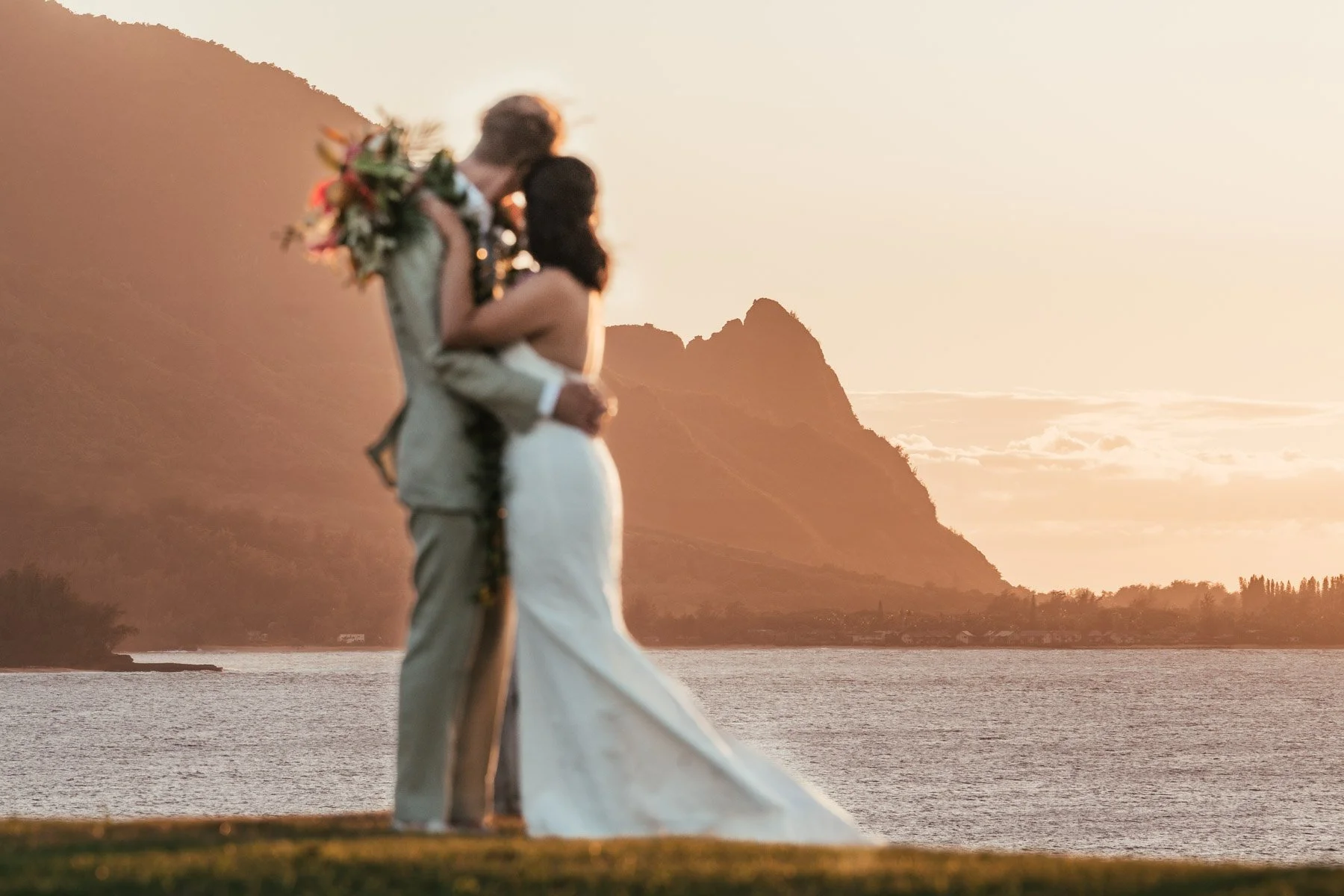 Bride and groom enjoy sunset from bluff at 1 Hotel Hanalei Bay