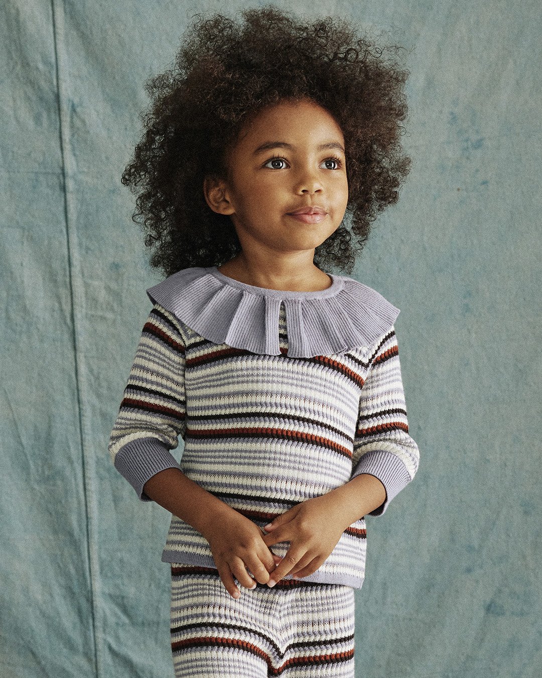 Multi-color textured stripe styles in a light Pima cotton knit, with fun ruffle details and versatile collars that layer exquisitely and adds flare to any outfit. Available in Pewter Stripe and Poppy Stripe.