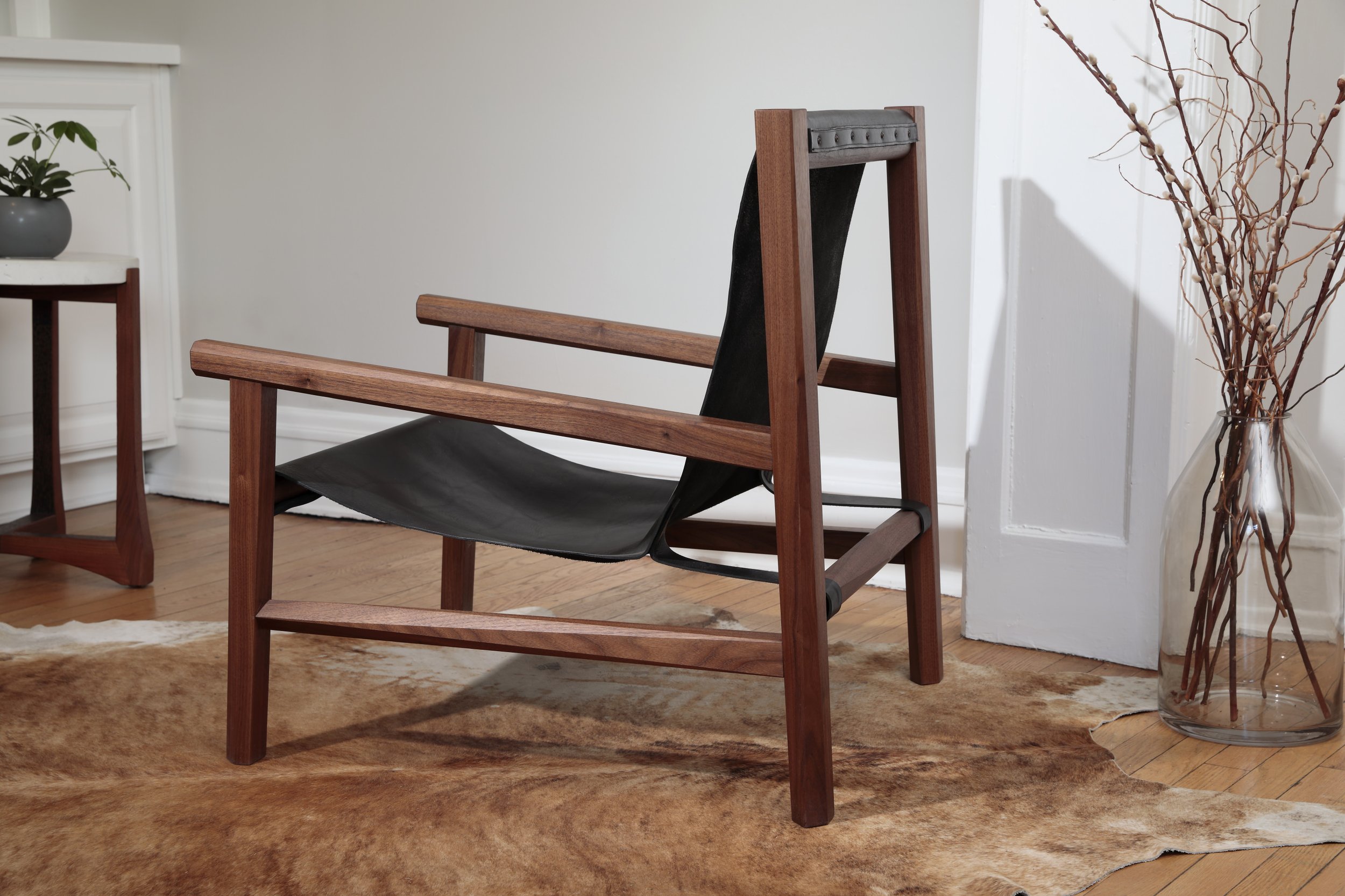 Combining the warmth of wood and the luxury of leather, this sling chair is the perfect place to spend an evening of relaxation. A collaboration between Alicia Dietz Studios and Awl Snap Leather, both women-owned business in Richmond, VA. A low and d