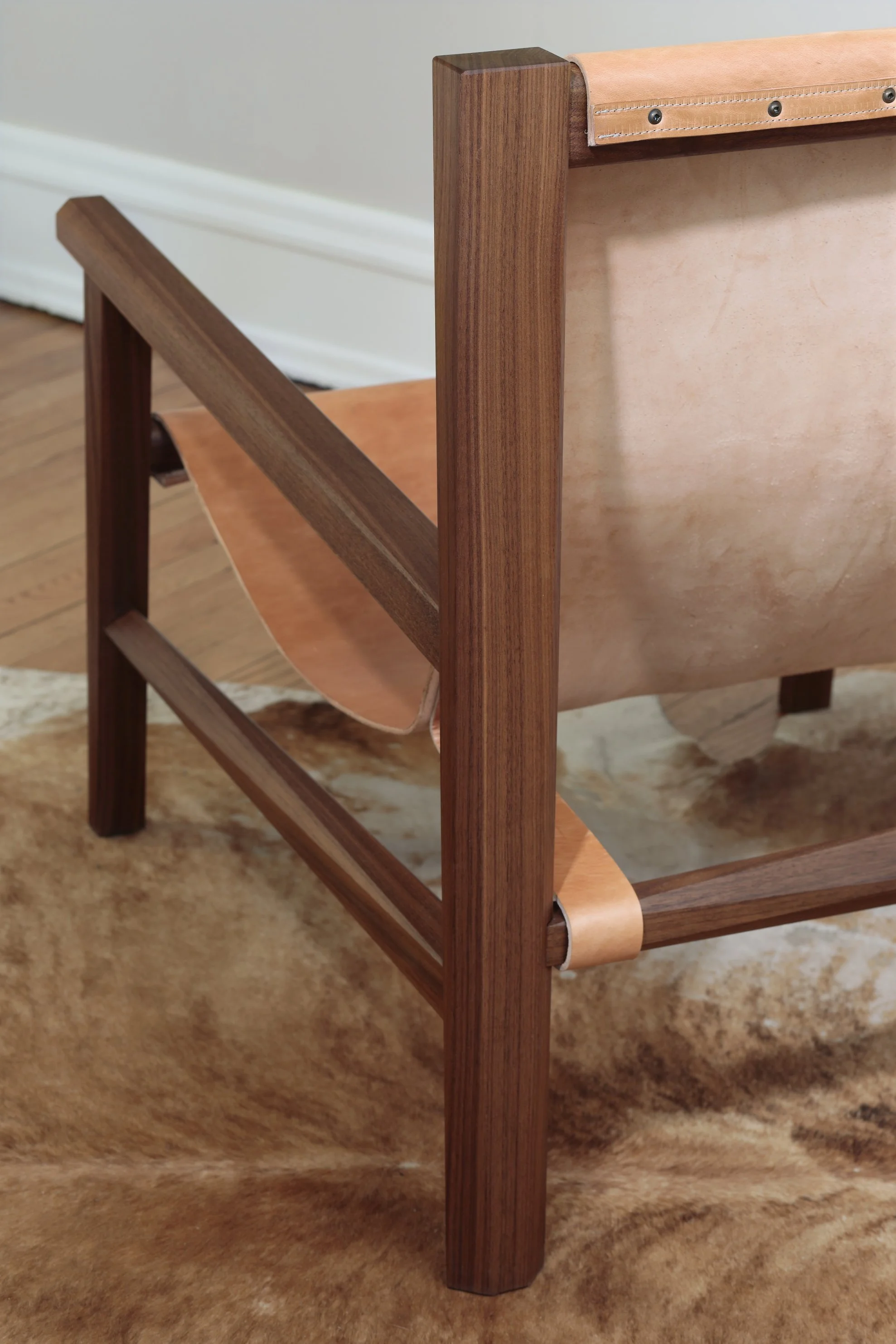 Combining the warmth of wood and the luxury of leather, this sling chair is the perfect place to spend an evening of relaxation. A collaboration between Alicia Dietz Studios and Awl Snap Leather, both women-owned business in Richmond, VA. A low and d