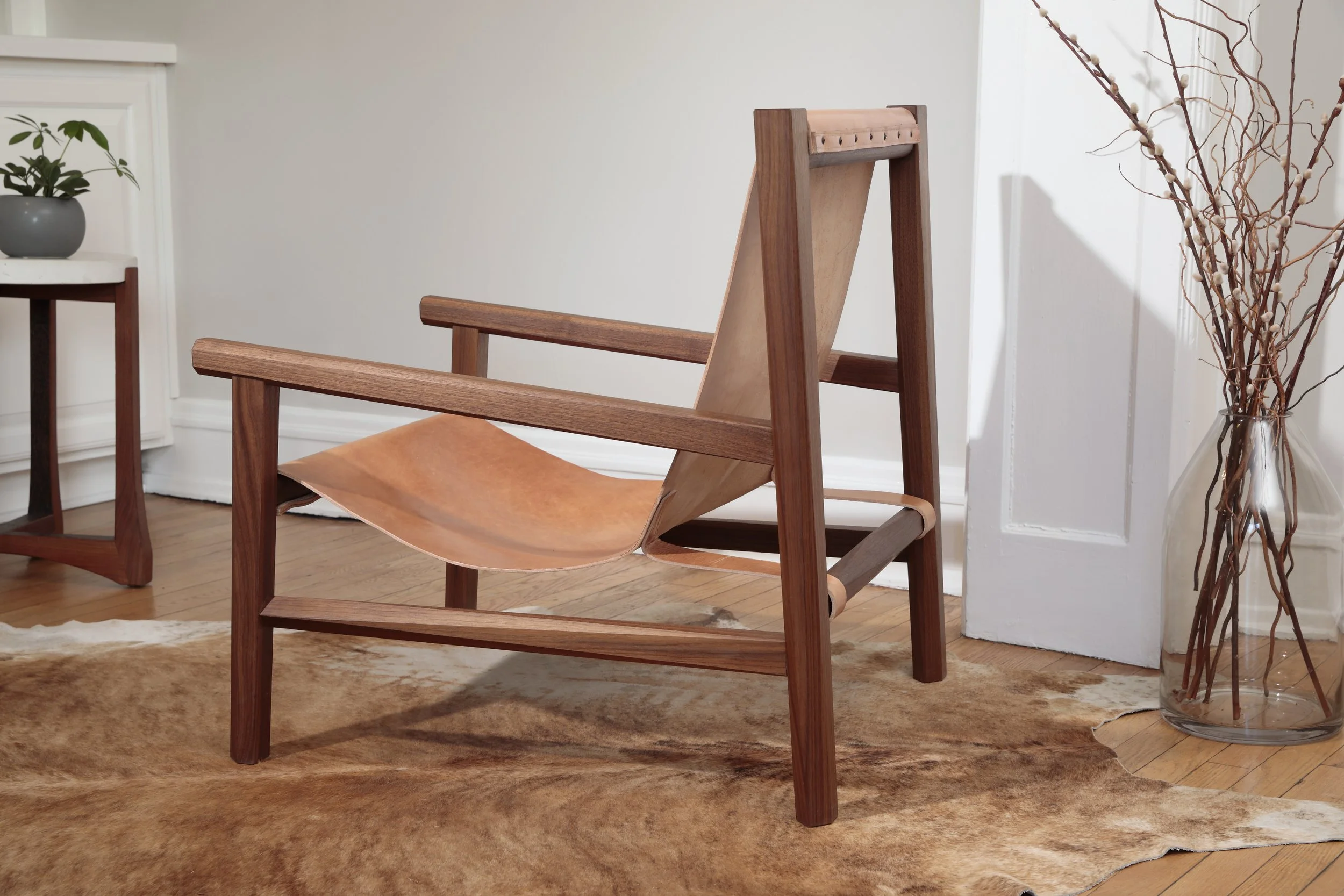 Combining the warmth of wood and the luxury of leather, this sling chair is the perfect place to spend an evening of relaxation. A collaboration between Alicia Dietz Studios and Awl Snap Leather, both women-owned business in Richmond, VA. A low and d