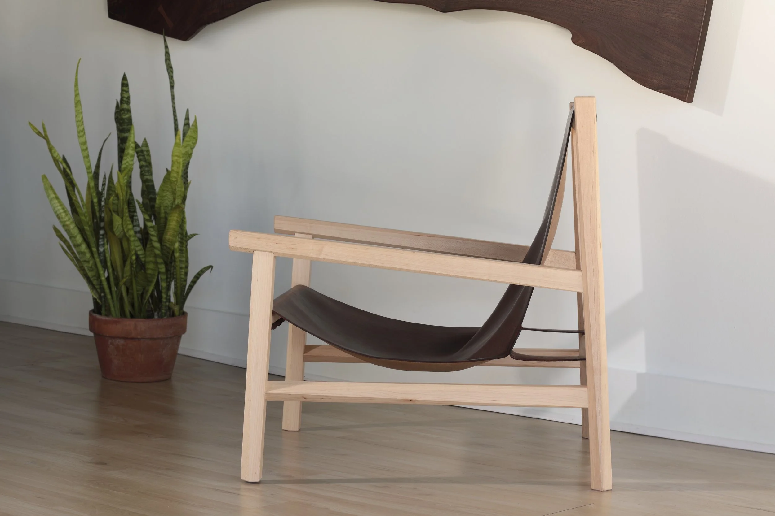 Combining the warmth of wood and the luxury of leather, this sling chair is the perfect place to spend an evening of relaxation. A collaboration between Alicia Dietz Studios and Awl Snap Leather, both women-owned business in Richmond, VA. A low and d