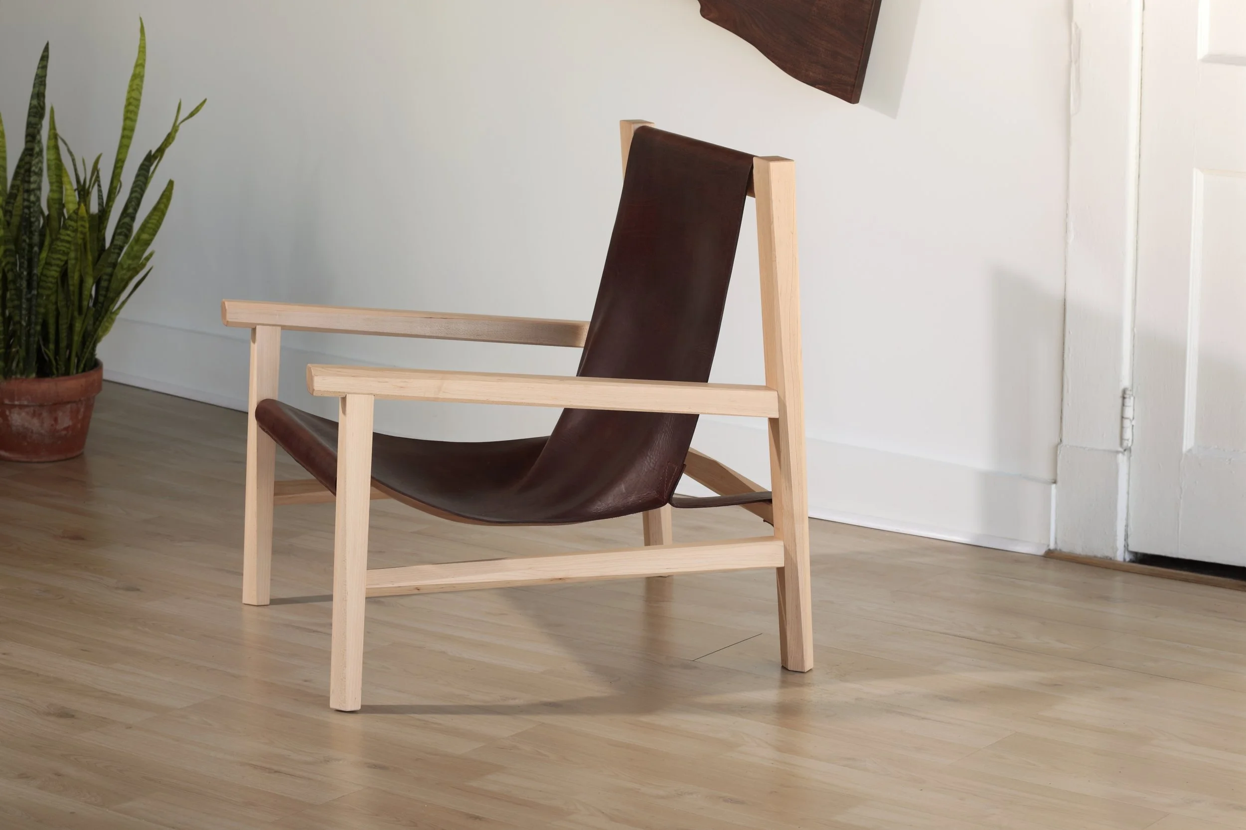 Combining the warmth of wood and the luxury of leather, this sling chair is the perfect place to spend an evening of relaxation. A collaboration between Alicia Dietz Studios and Awl Snap Leather, both women-owned business in Richmond, VA. A low and d