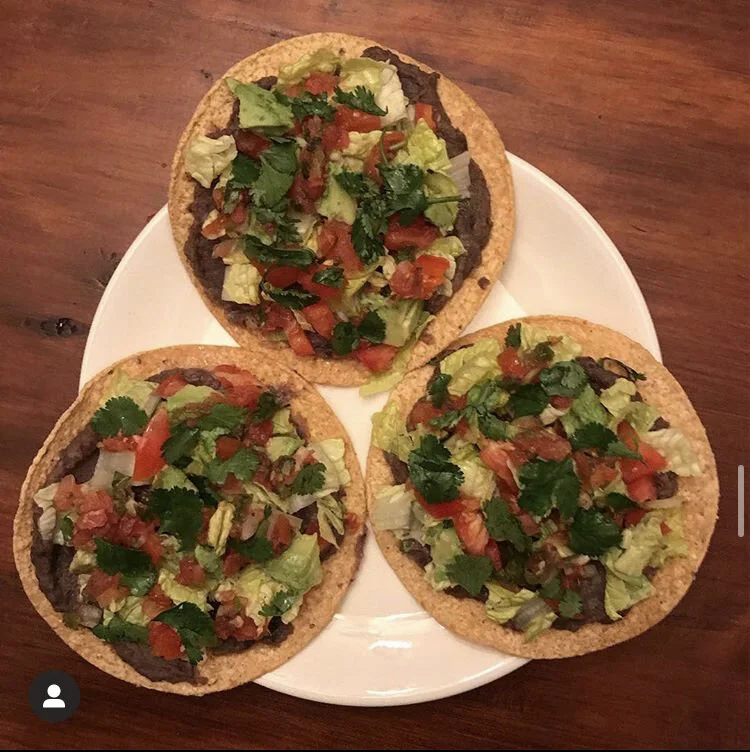 Tostadas with - refried black beans, romaine lettuce, avocado, tomato, Pico de Gallo, fresh cut cilantro, & lime