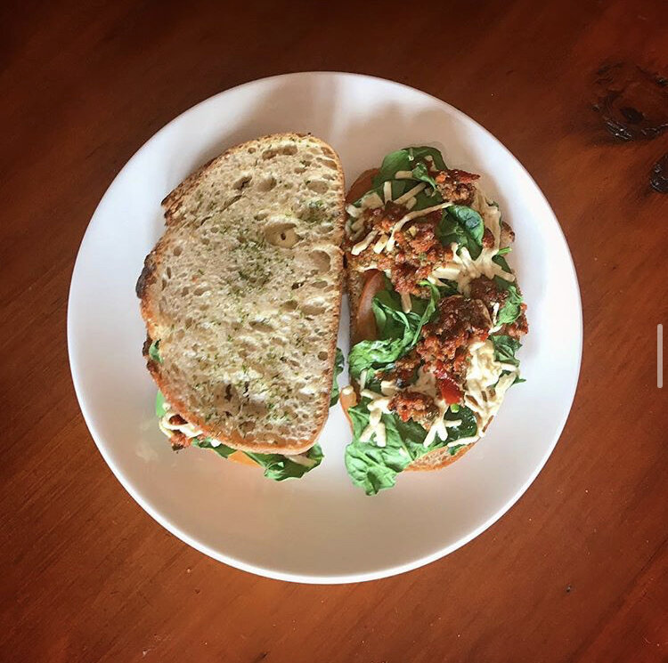 Panini with vegan mozzarella, sun dried tomato pesto, spinach, and regular tomatoes served on toasted sourdough seasoned with parsley & garlic