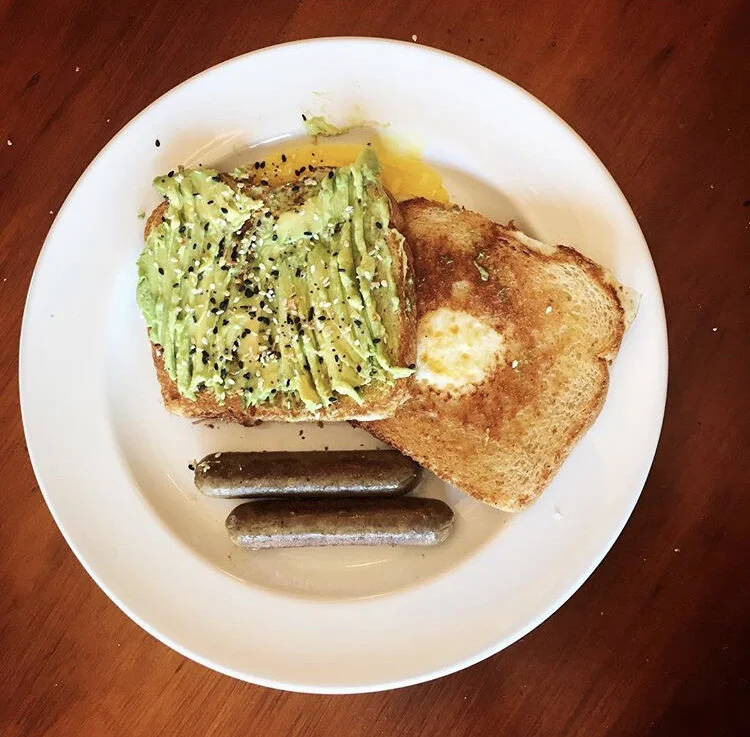 Avocado Toast with Everything bagel seasoning, and egg in a nest, with vegan sausages