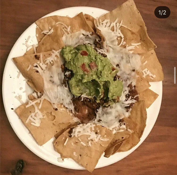 Super Nachos, vegan cheese, guacamole with tomatoes, and refried beans 