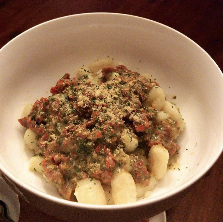 Non - Dairy Creamy sun dried tomato pesto gnocchi topped w/home-made vegan parmesan paired 