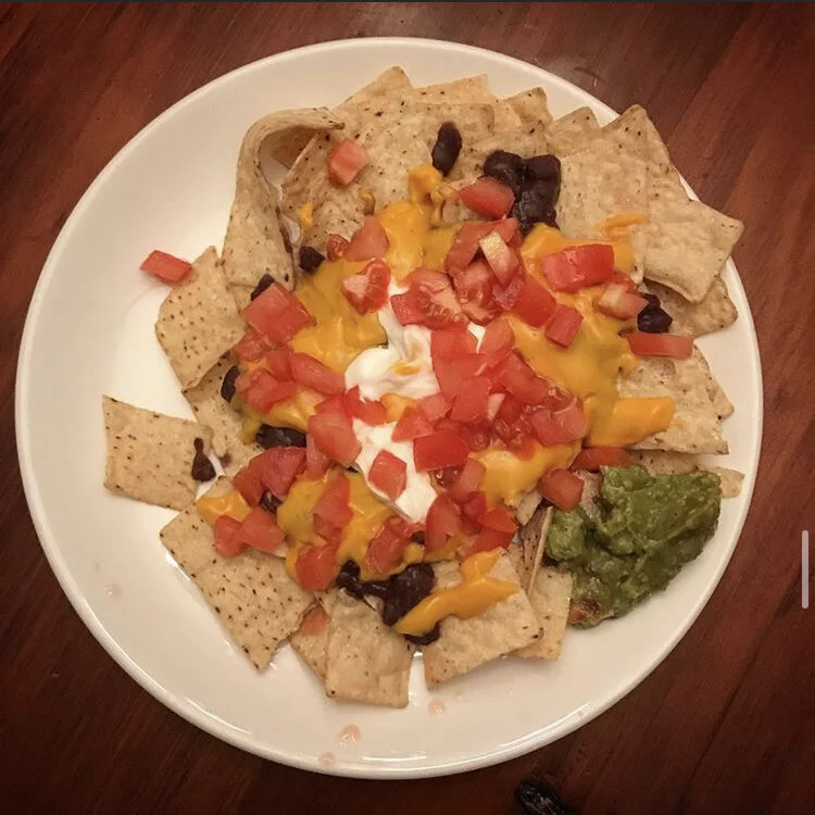 Nachos - Nacho cheese, tomatoes, guacamole, chips, black beans, vegan sour cream