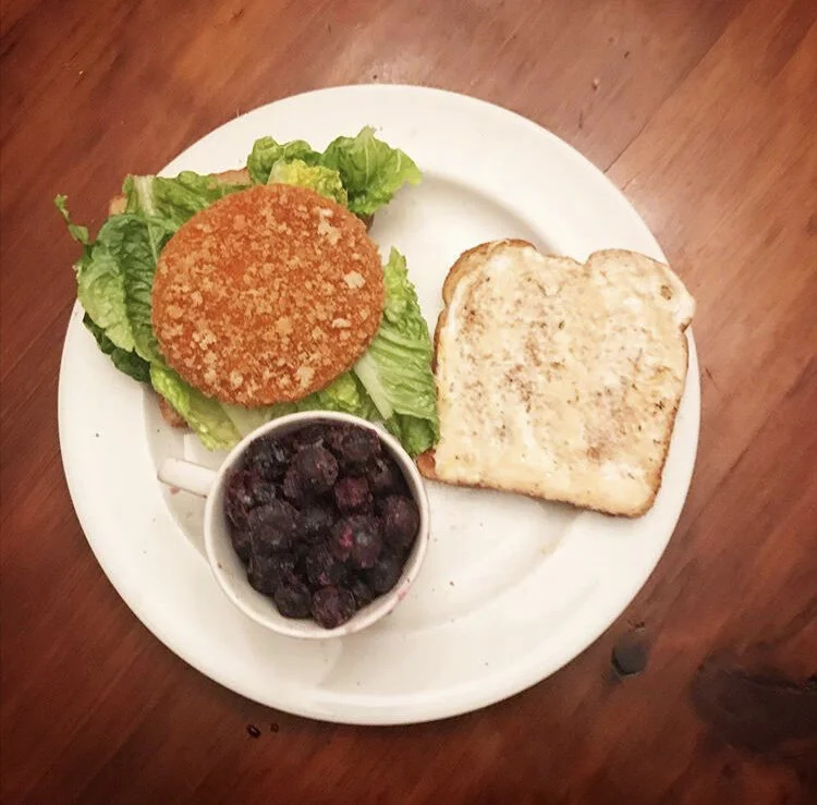 Spicy Chicken Sandwich - vegan chicken patty, franks buffalo sauce / vegan ranch, lettuce, tomato, and a cup of frozen blueberries 