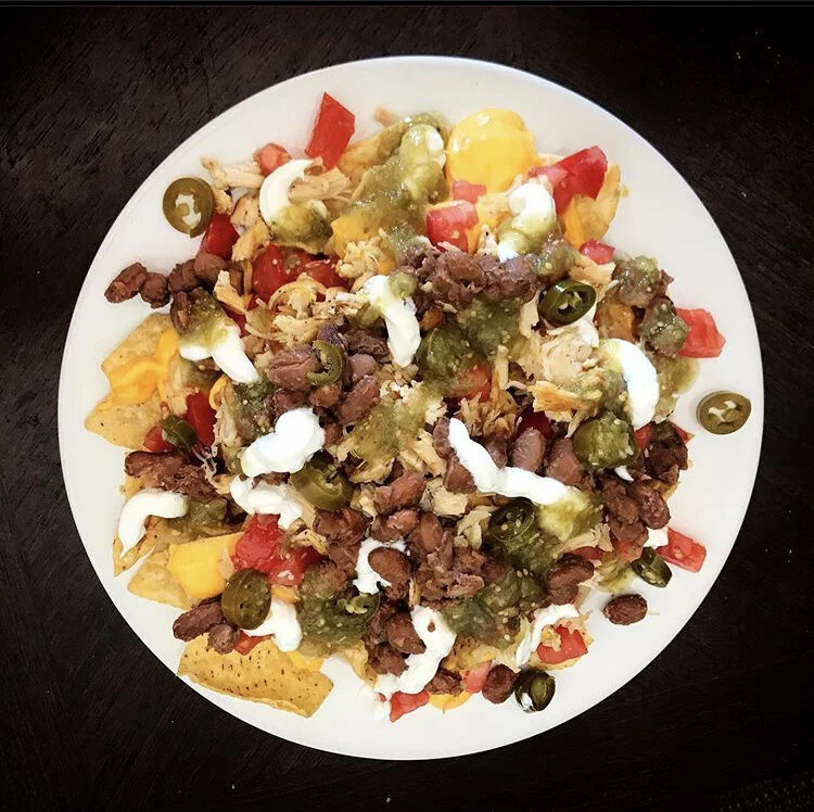Fully loaded Nachos - chips, green salsa, beans, tomatoes, shredded chicken, jalapeños, and sour cream 