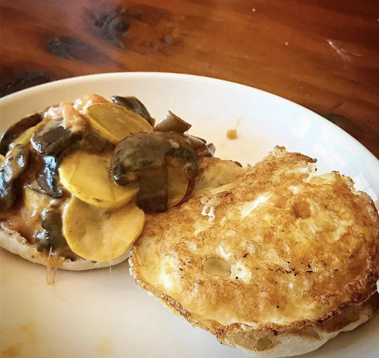 English Muffin, mushrooms, yellow squash, cheese slice, tomatoes, and a fried egg 