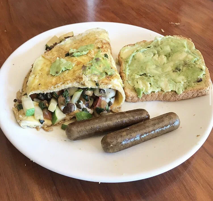 Veggie Omelette (zucchini, mushrooms, tomato, spinach, vegan cheese, & eggs) ,  avocado toast, and vegan sausage 
