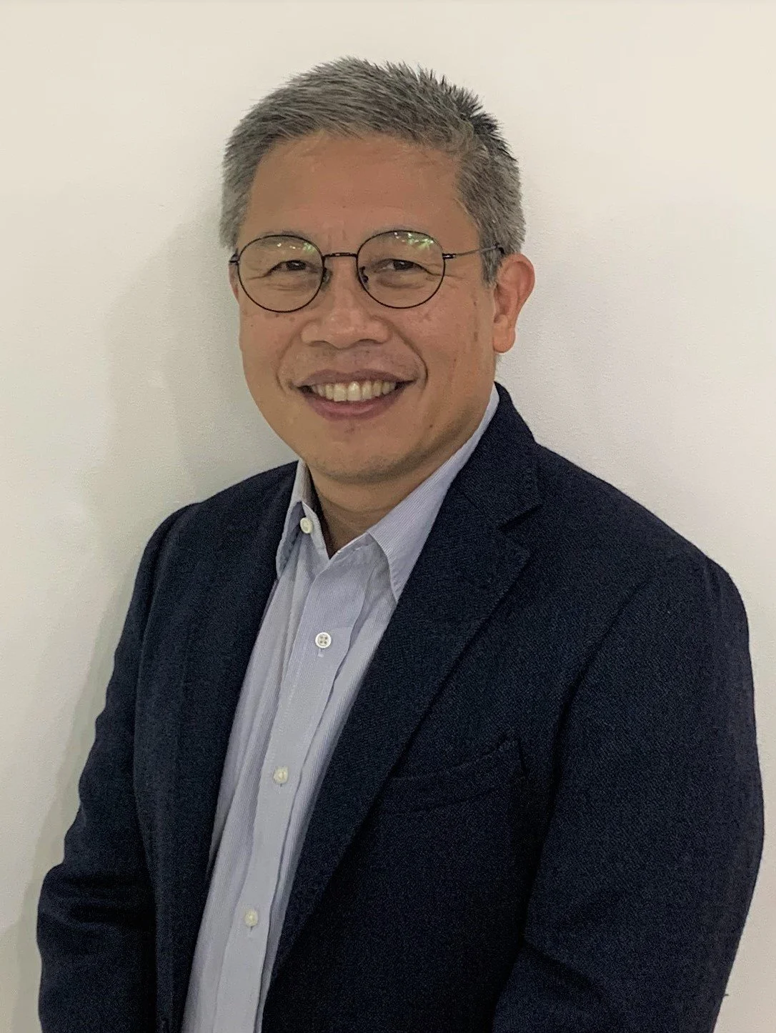 Mr. Rafa Lopa, president and chairman of RESTARTME. A man wearing glasses in a suit and light blue dress shirt, smiling against a plain white background.