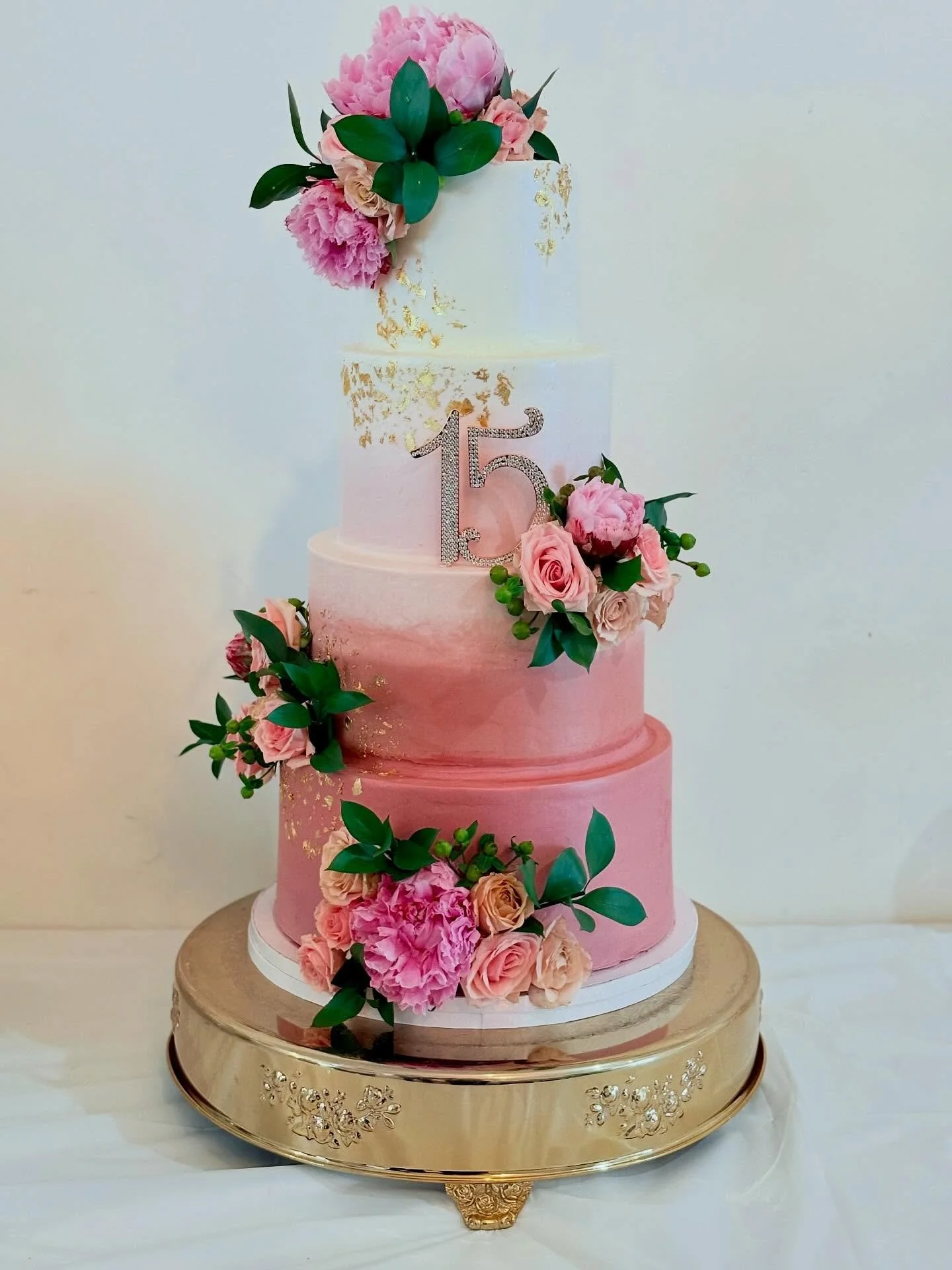 Quincea&ntilde;era cake with an ombr&eacute; effect, fresh roses and peonies and gold details 💕