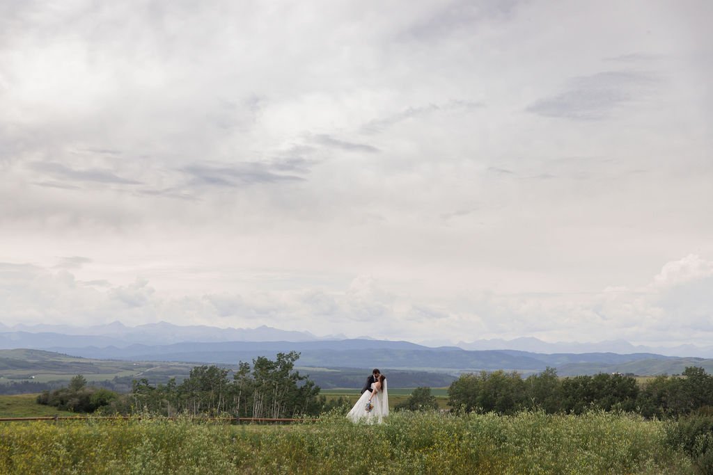 a wedding couple dip in panoramic taken at wolf willow lodge out by longview by a calgary alberta wedding photographer