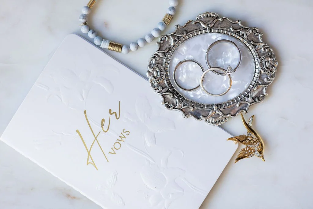 a detail flatlay taken by a yyc wedding photographer capturing vows, rings and special elemtents