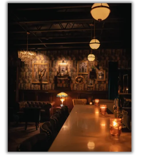 Candlelit bar and vintage decor inside Roost 374 speakeasy next door to Flights & Irons in San Clemente