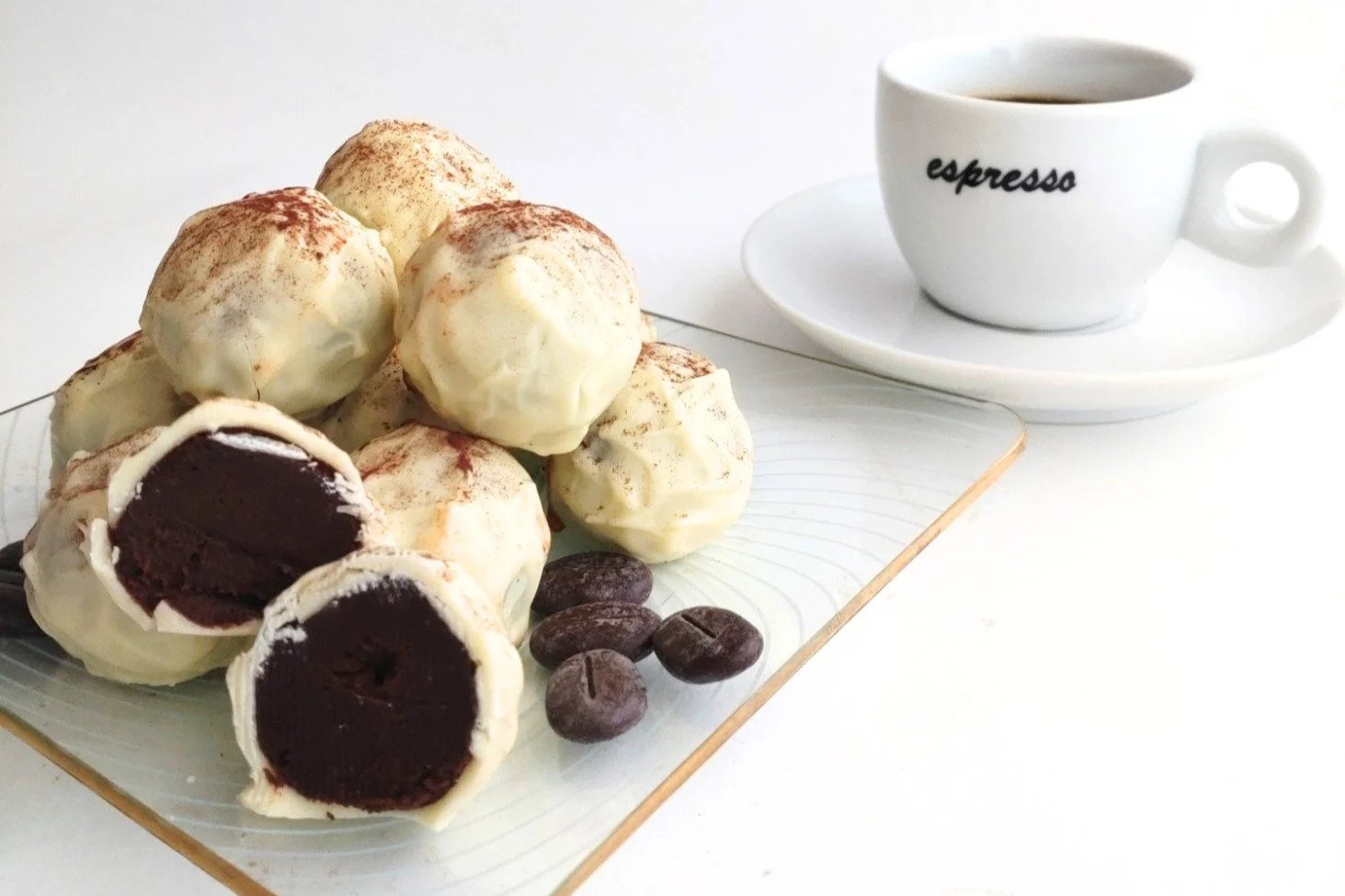 White chocolate coffee truffles dusted with cocoa, served with coffee beans and a cup of espresso.