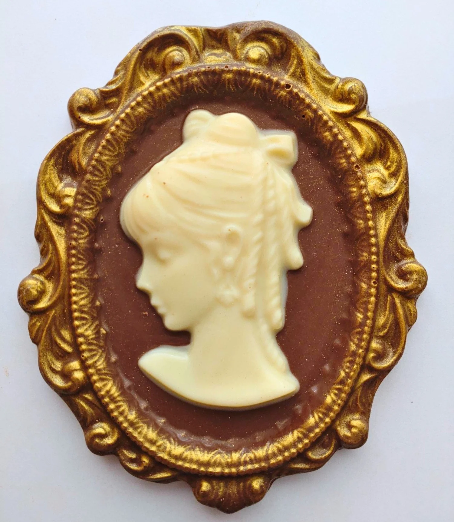 Cameo made from milk and white chocolate, dusted with gold lustre.